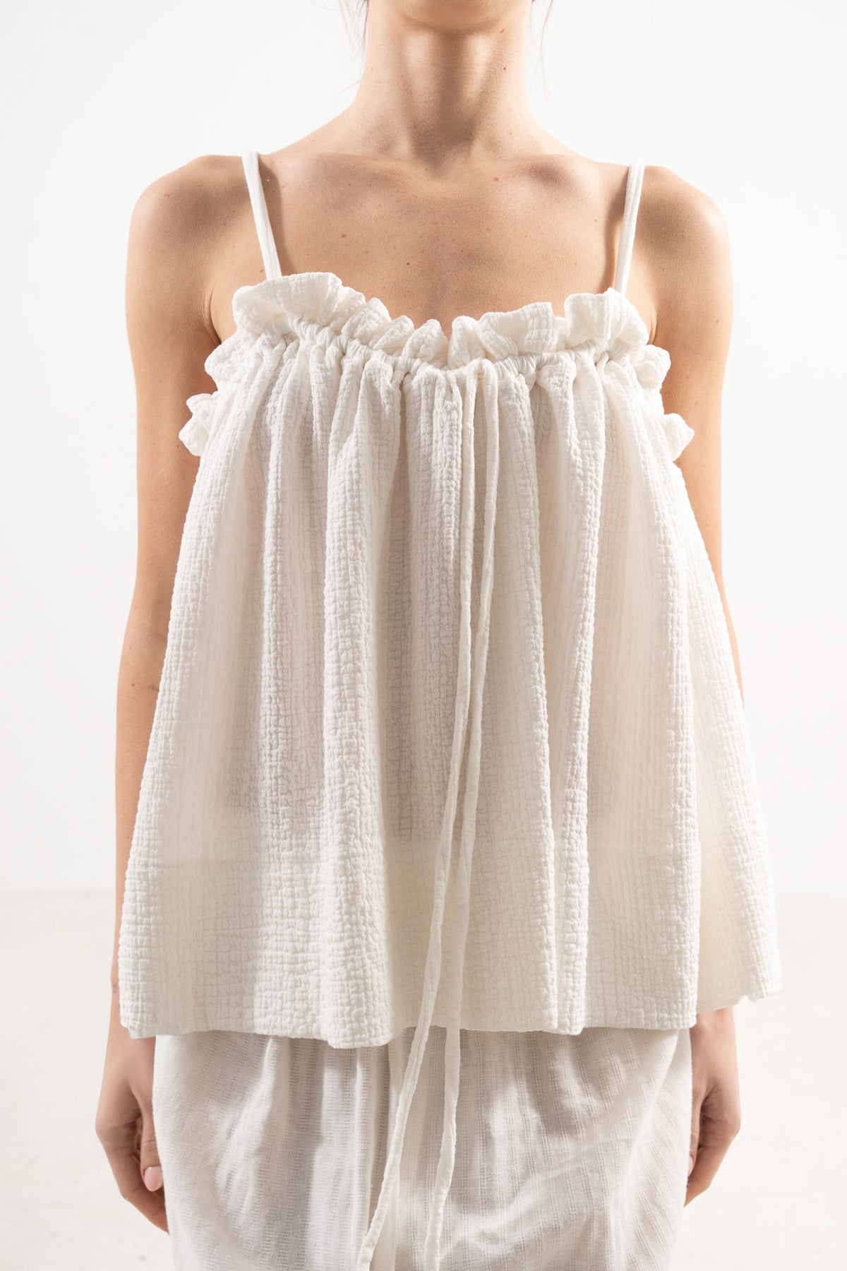 Close-up detail shot focusing on the fine stitching, delicate straps, and premium weave of the pure MOCHA organic cotton fabric.