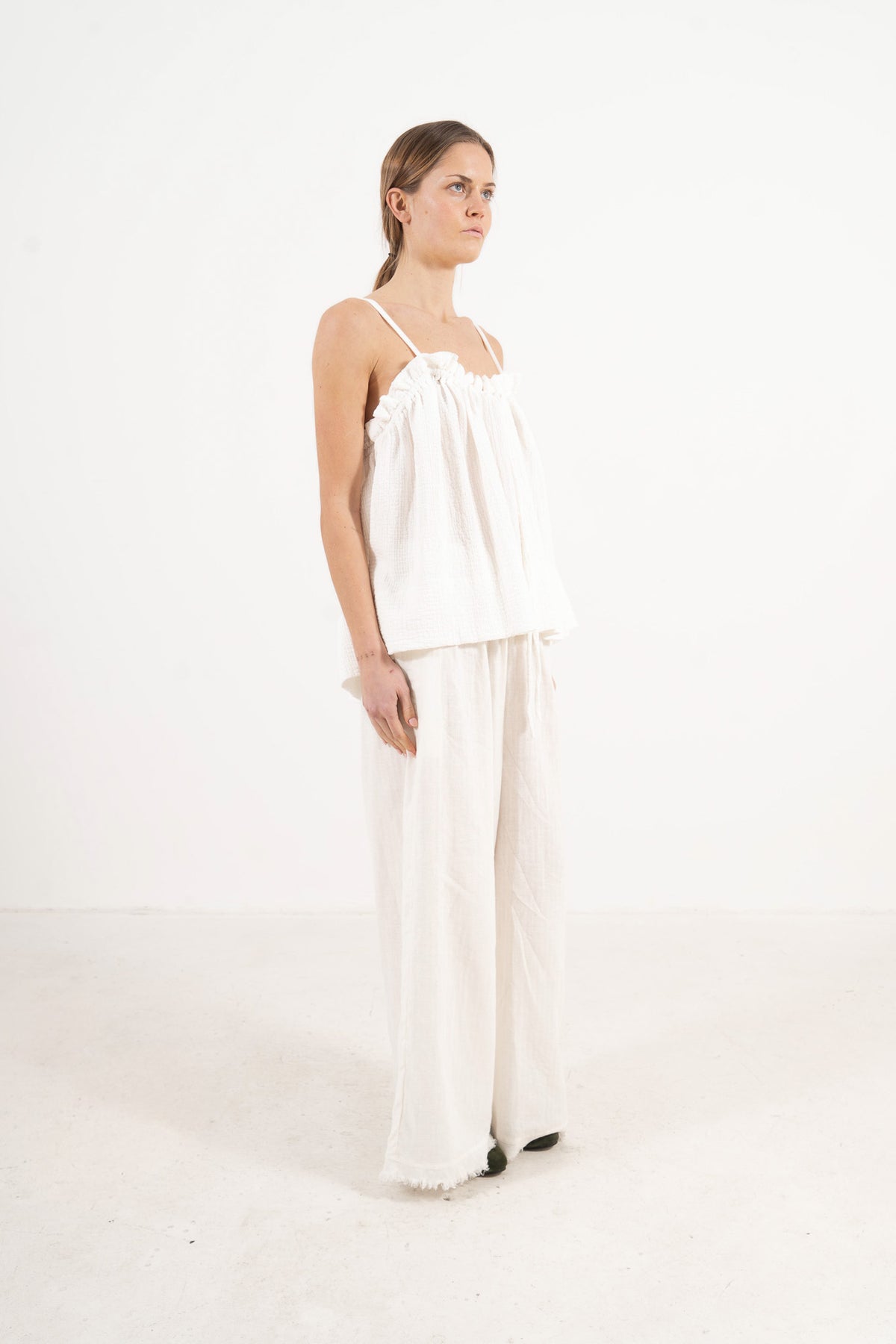 Side lookbook capture of the premium cotton top, emphasizing its light, airy drape inspired by movement and gentle days.