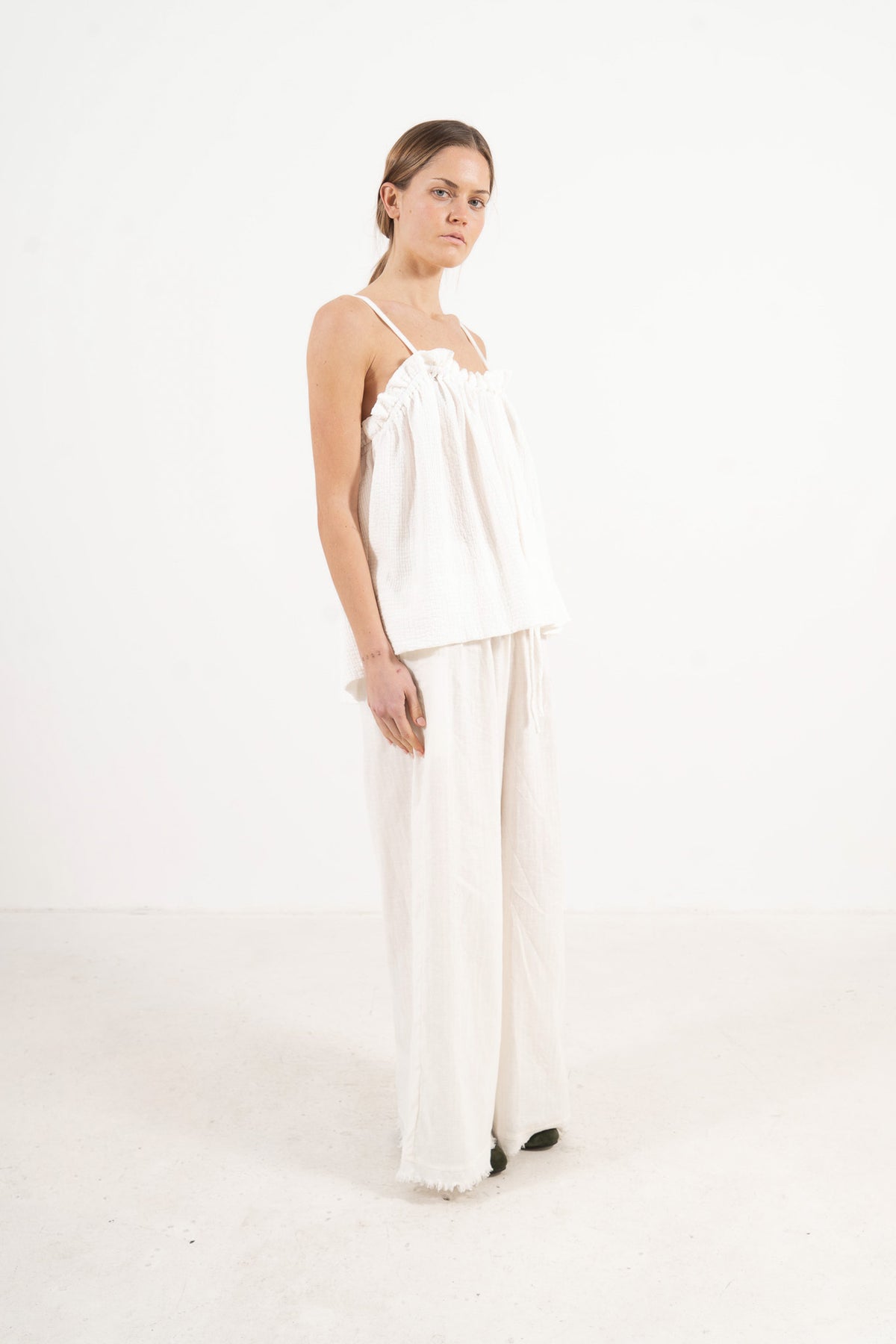 Side lookbook capture of the premium cotton top, emphasizing its light, airy drape inspired by movement and gentle days.