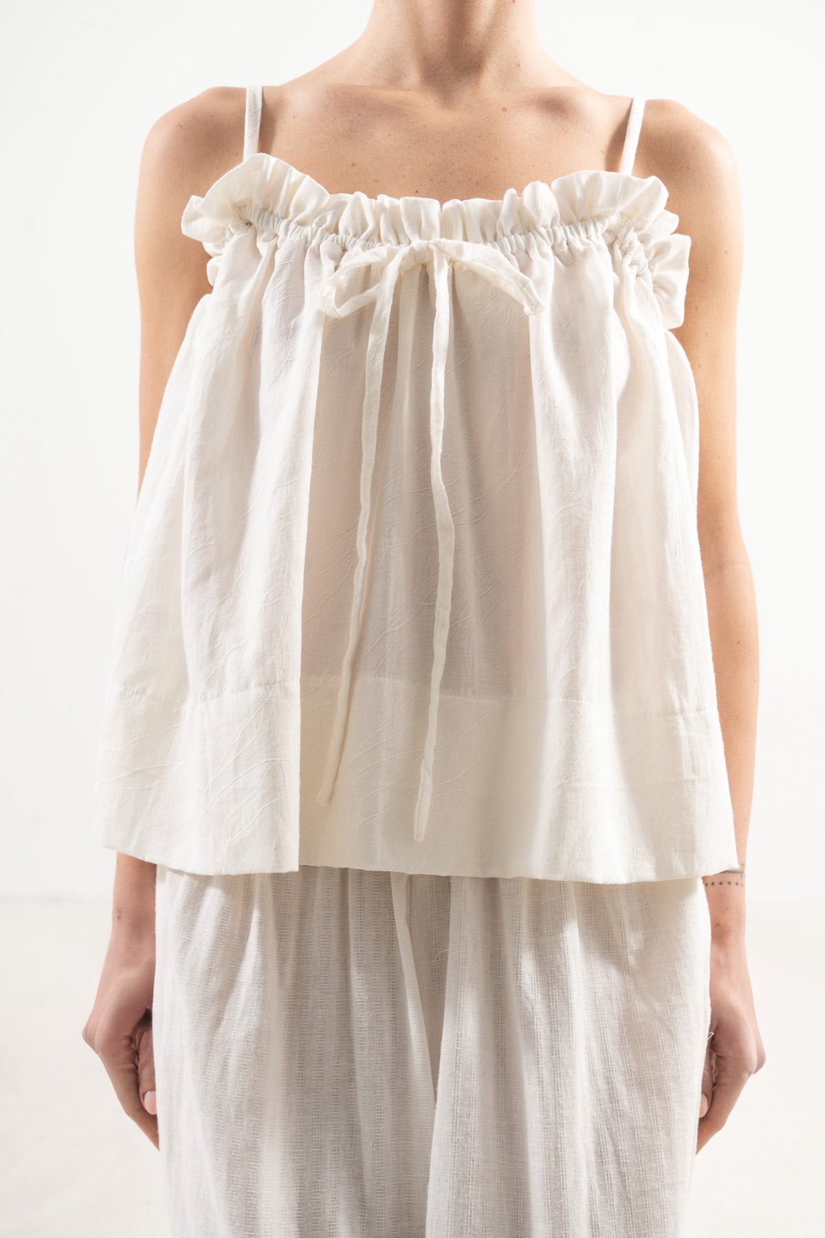 An exquisite close-up detail of the MOCHA Adeline top, celebrating the fine premium soft cotton weave, delicate finishings, and superior fabric texture.