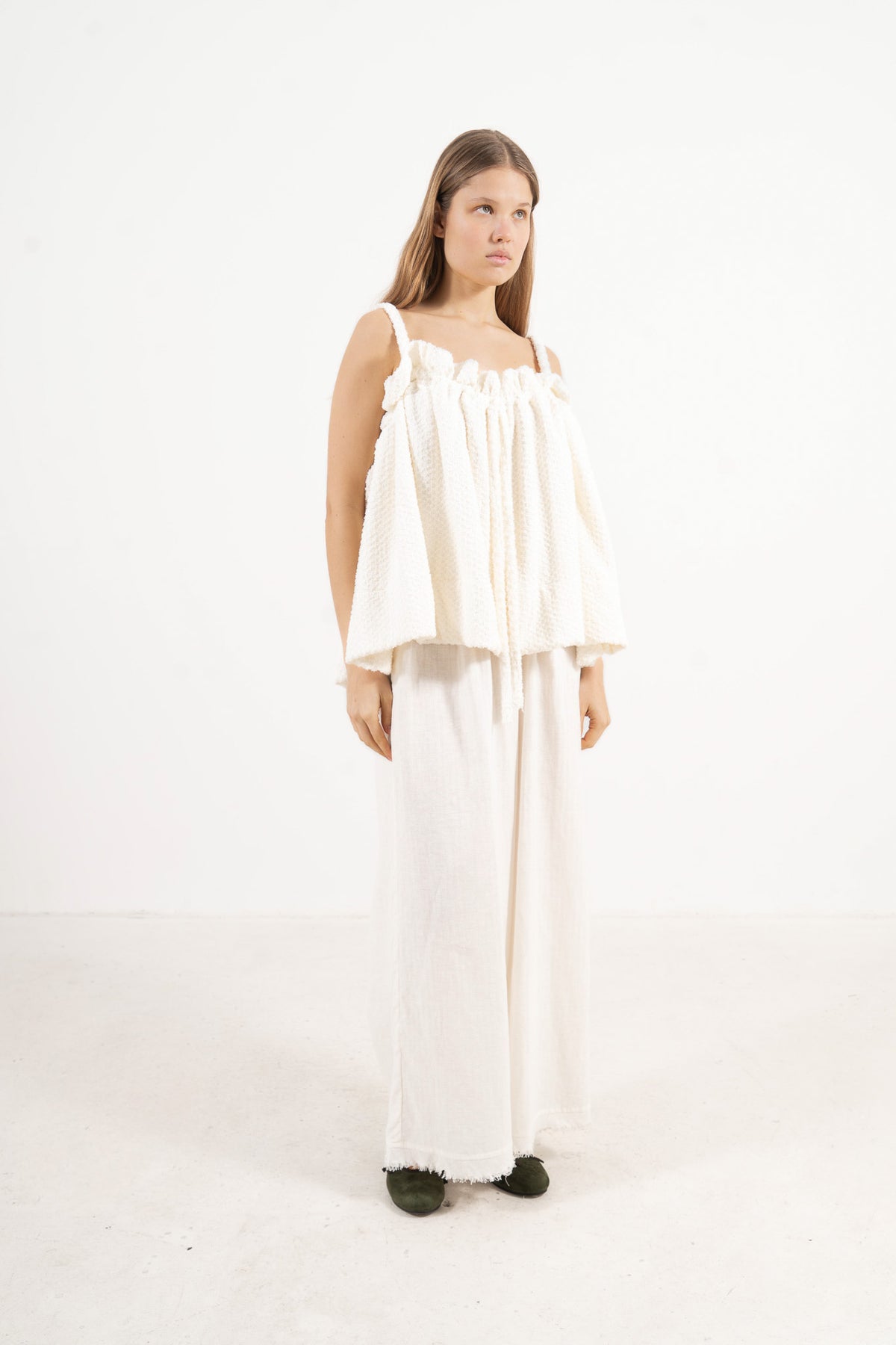 Profile studio portrait showcasing the versatile fit and delicate straps of the MOCHA Adeline top in soft white cotton.