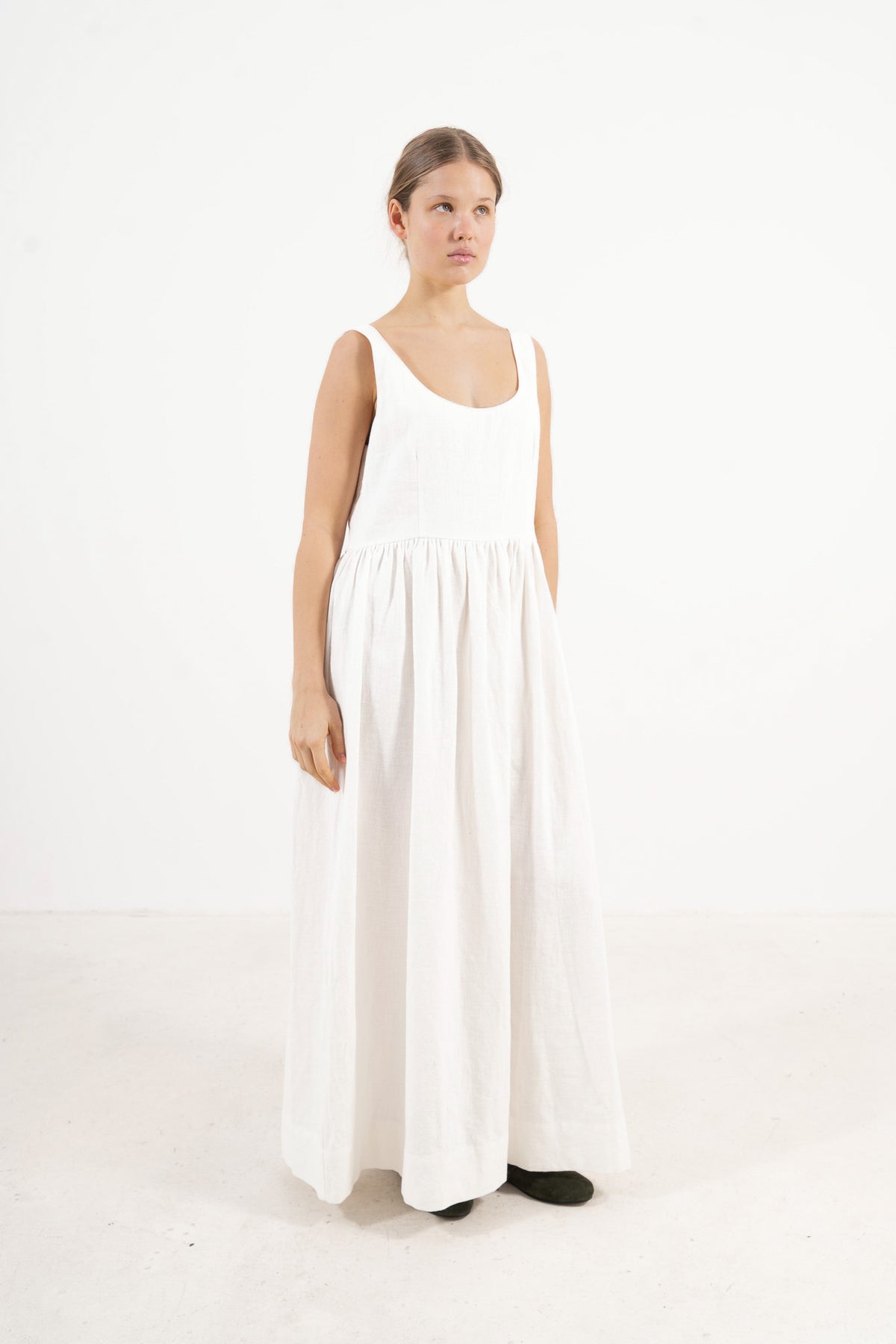 A poetic side angle view of the luxury cotton and ramie MOCHA Amandine garment, showcasing its composed, timeless silhouette cascading softly against a white backdrop.
