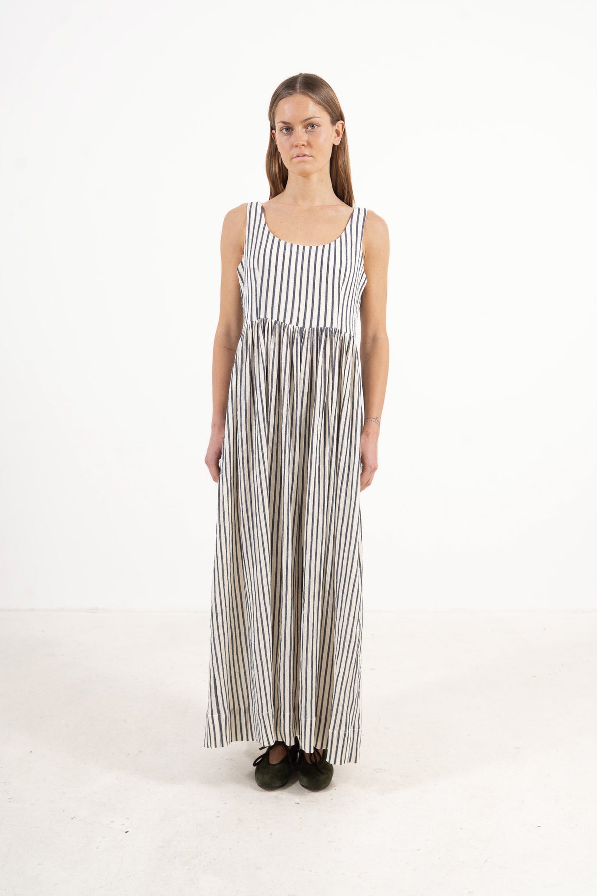 Front view studio portrait featuring a model in the striped Amandine long dress by MOCHA, embodying a soft world of lightness and ease.