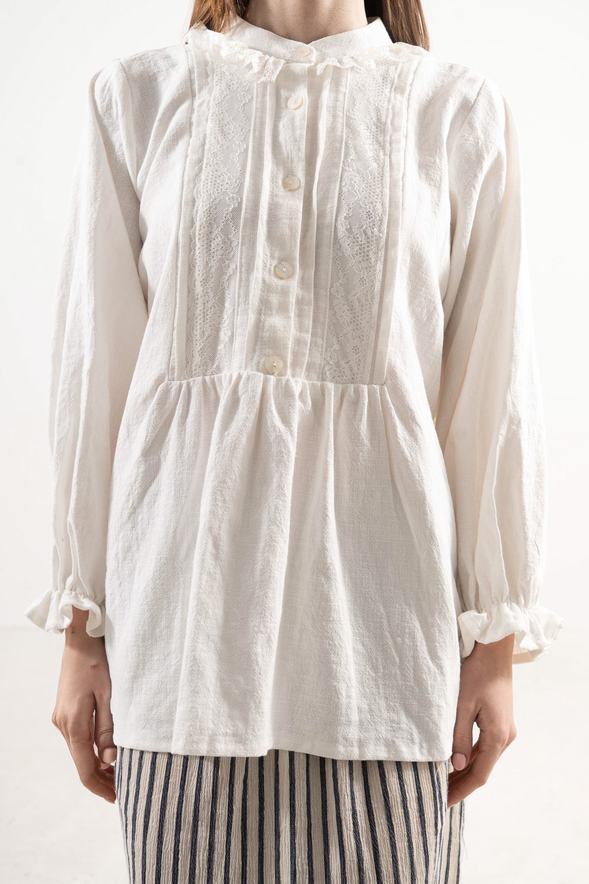 Close-up detail shot focusing on the delicate collar, ruffled details, and premium texture of the pure MOCHA organic cotton fabric.