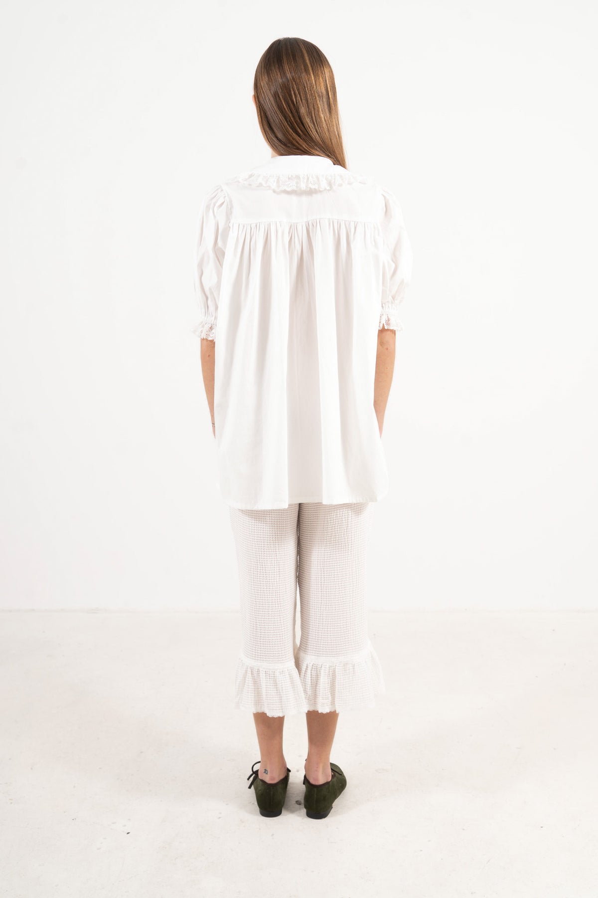 Back view of the timeless organic cotton blouse on a model, capturing a sense of ease and understated femininity.