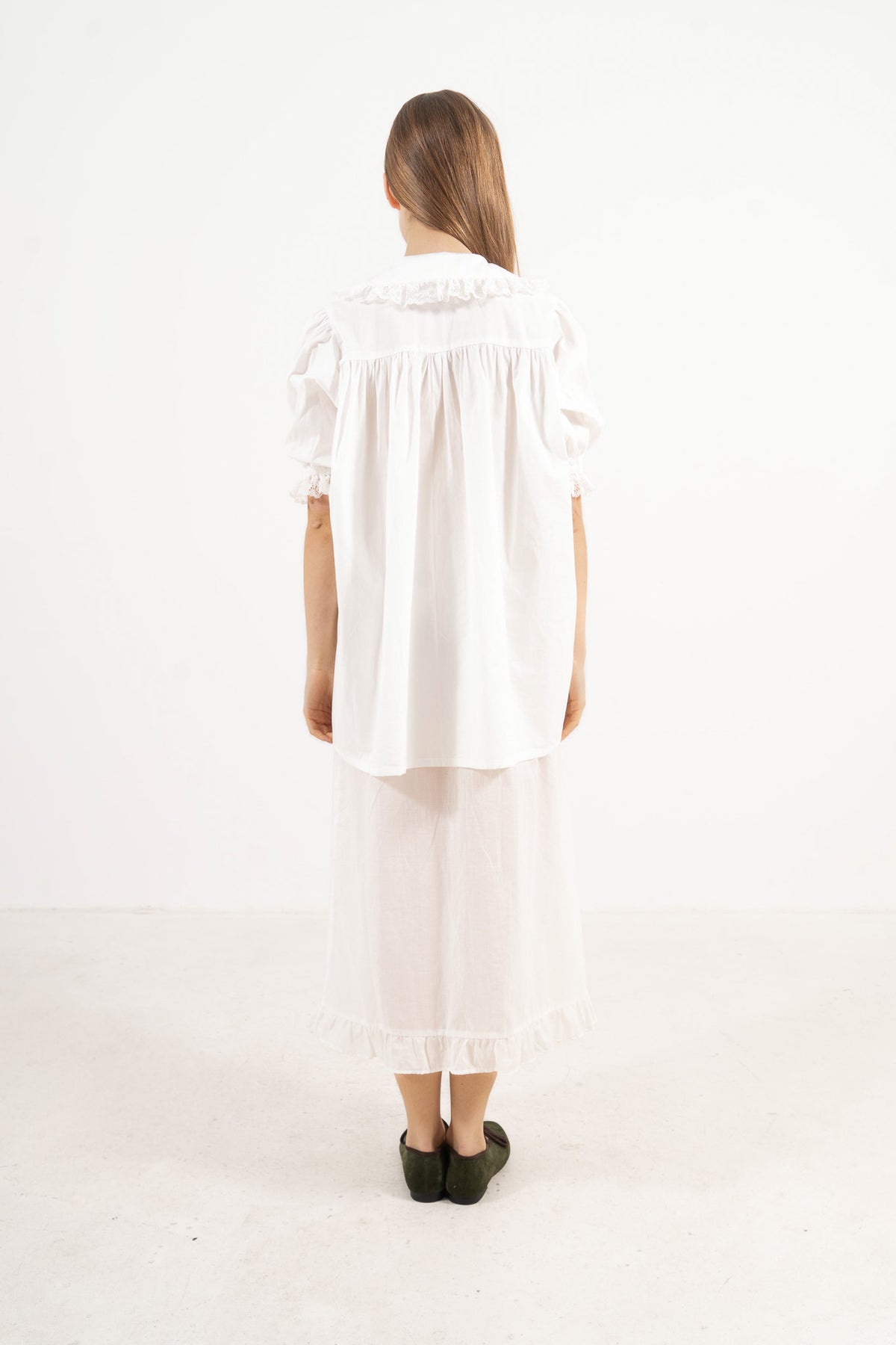 Back view of the timeless organic cotton blouse on a model, capturing a sense of ease and understated femininity.