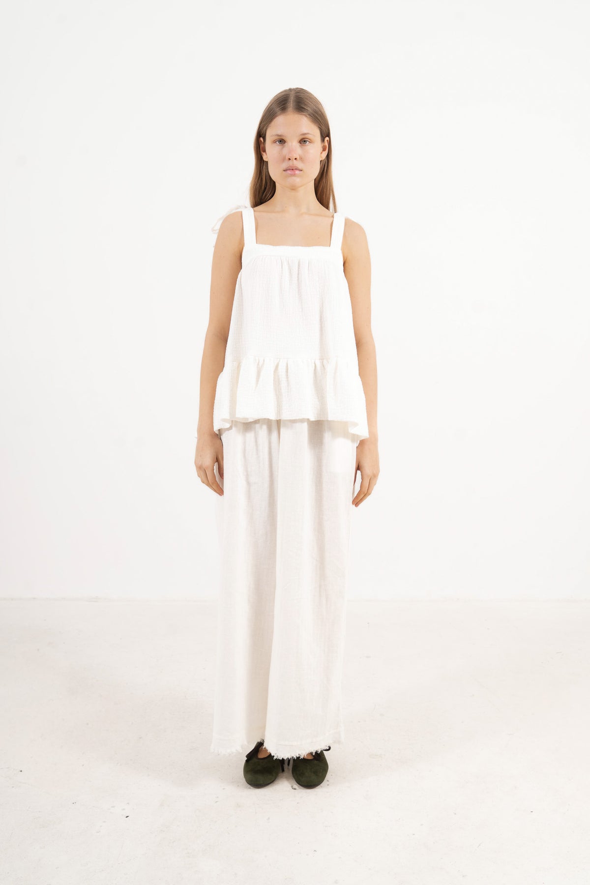 Front view studio portrait featuring a model in the white Belle top by MOCHA, capturing its subtle detailing and quiet femininity.