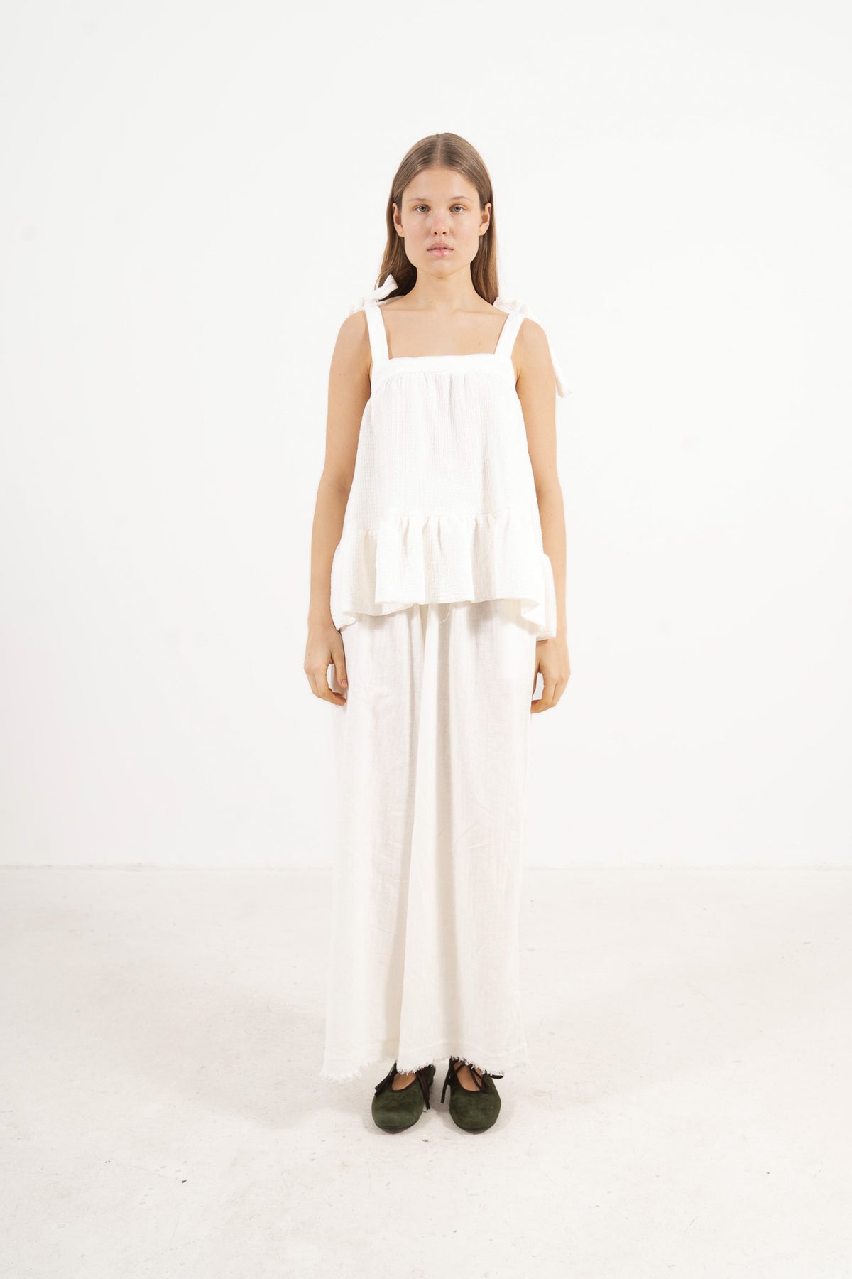 Front view studio portrait featuring a model in the white Belle top by MOCHA, capturing its subtle detailing and quiet femininity.