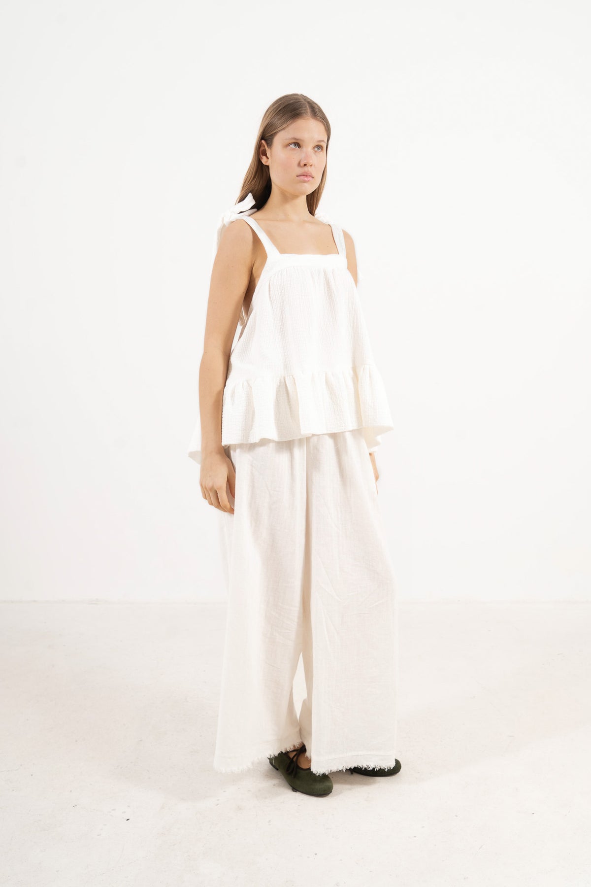 Profile studio portrait showcasing the versatile fit, clean lines, and pure structure of the MOCHA Belle top.