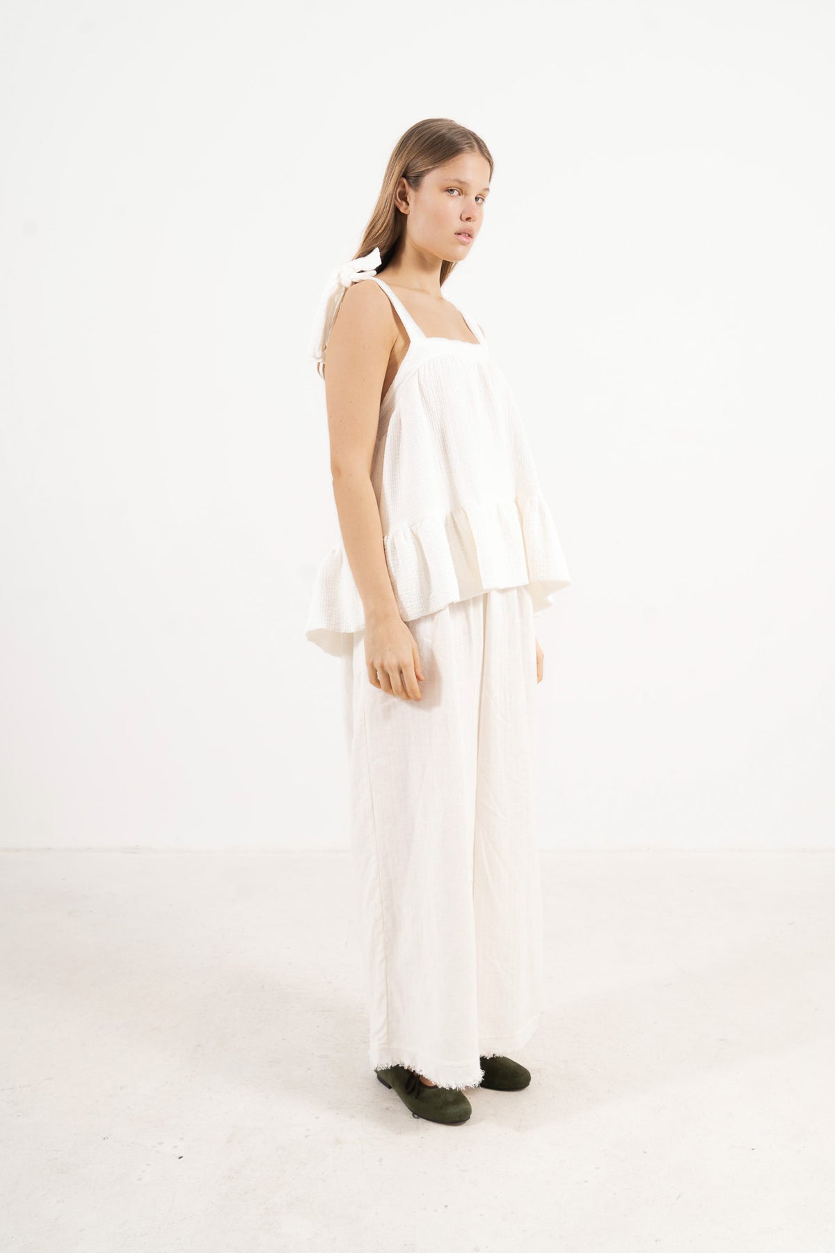 Side lookbook capture of the organic cotton top with straps, emphasizing its light, airy drape inspired by movement and gentle days.