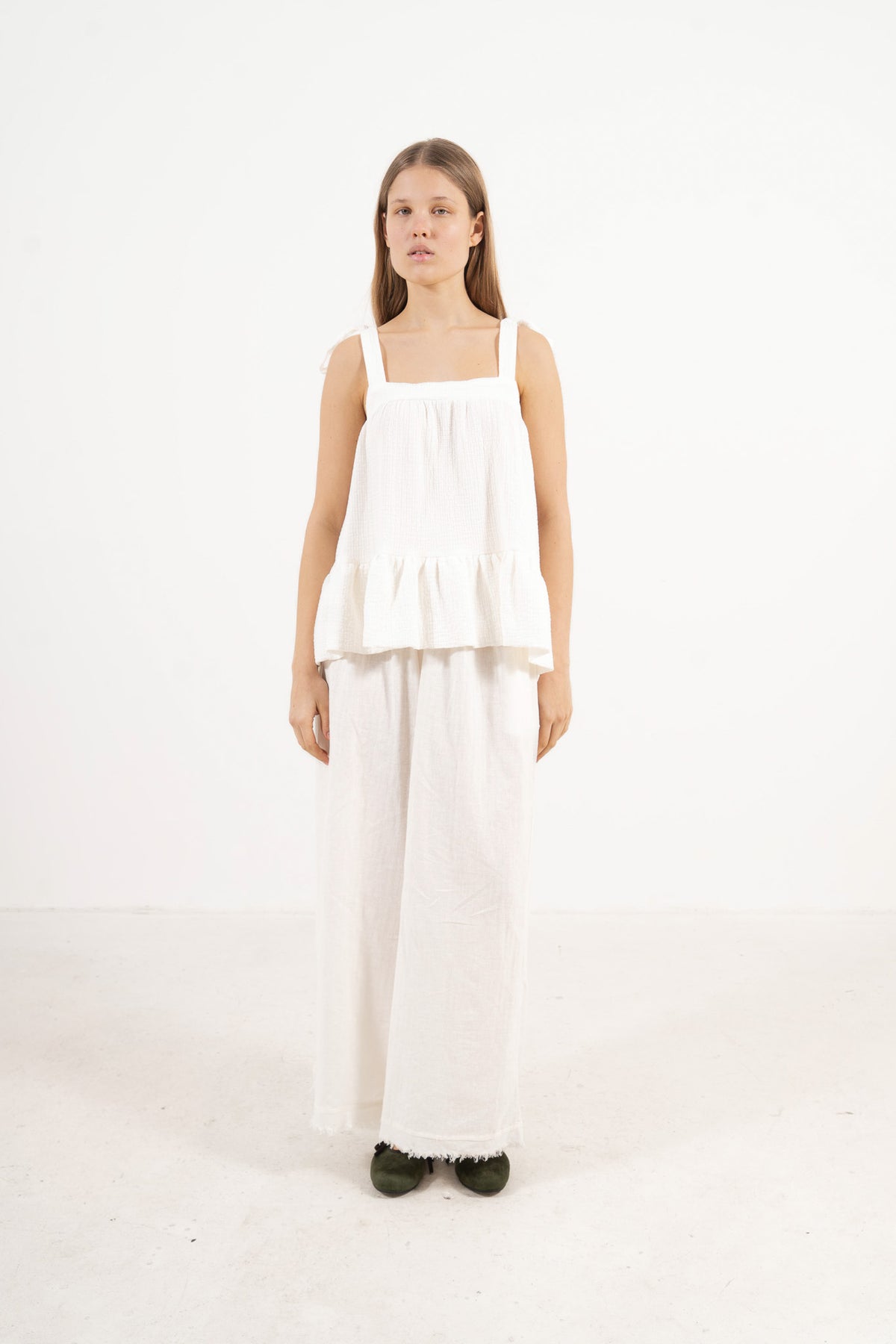 Side lookbook capture of the organic cotton top with straps, emphasizing its light, airy drape inspired by movement and gentle days.