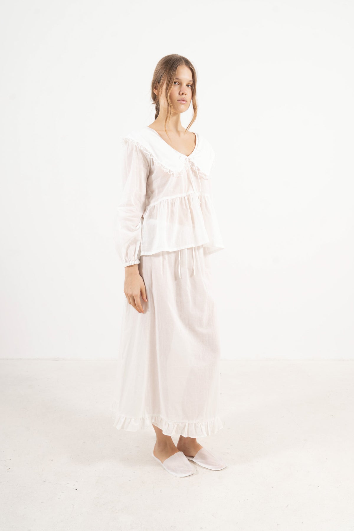 Profile studio portrait showcasing the refined minimalist tailoring, clean lines, and soft structural aesthetic of the MOCHA blouse.