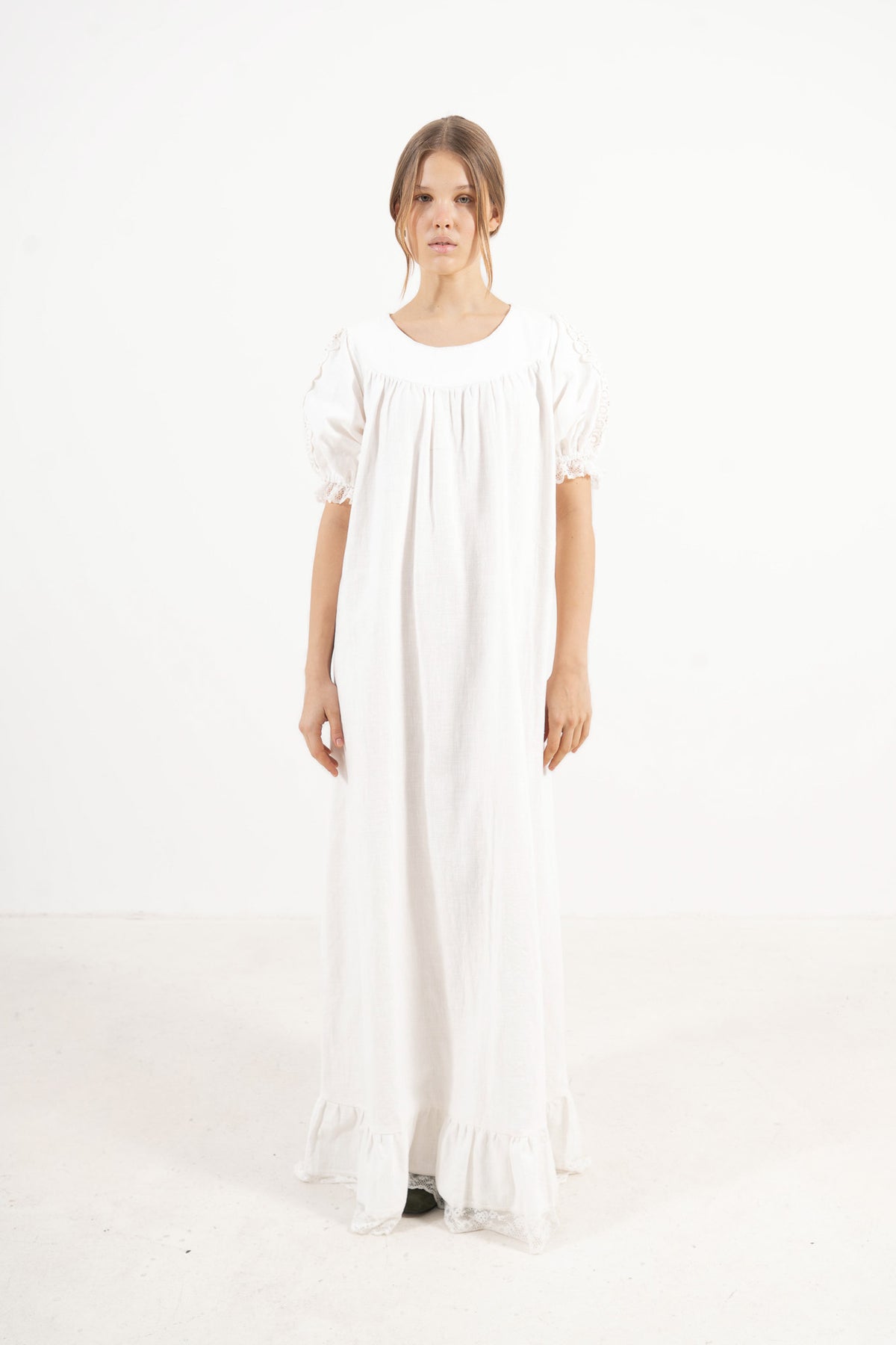 Front view studio portrait featuring a model in the white Éloise long dress by MOCHA, capturing its effortless elegance and gentle movement