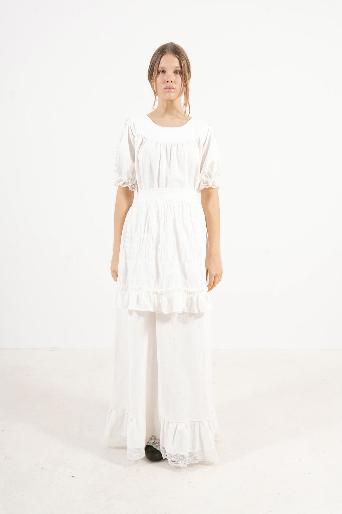 Front view studio portrait featuring a model in the white Éloise long dress by MOCHA, capturing its effortless elegance and gentle movement.