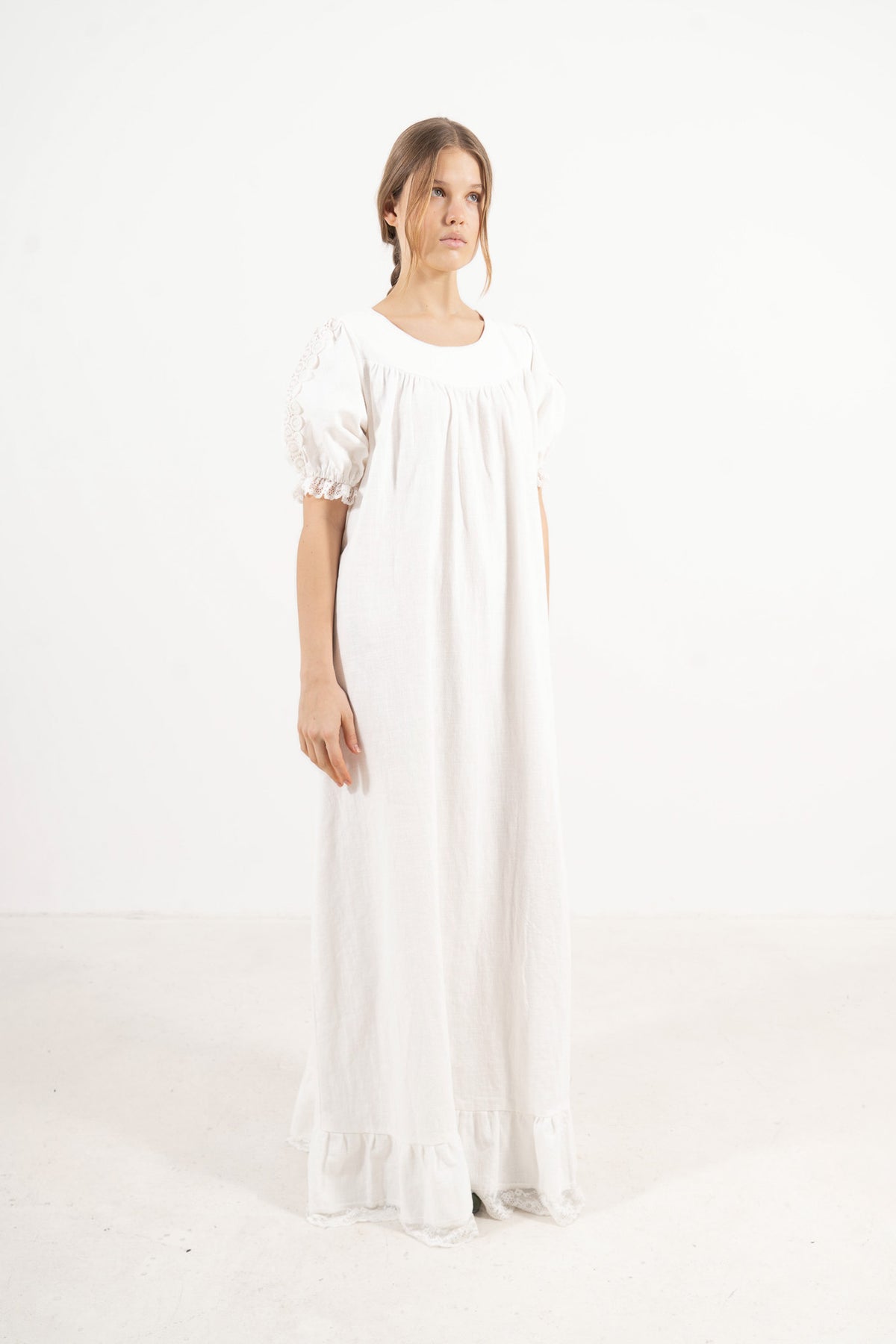 Profile studio portrait showcasing the refined long silhouette, structural lines, and graceful presence of the MOCHA Éloise dress.