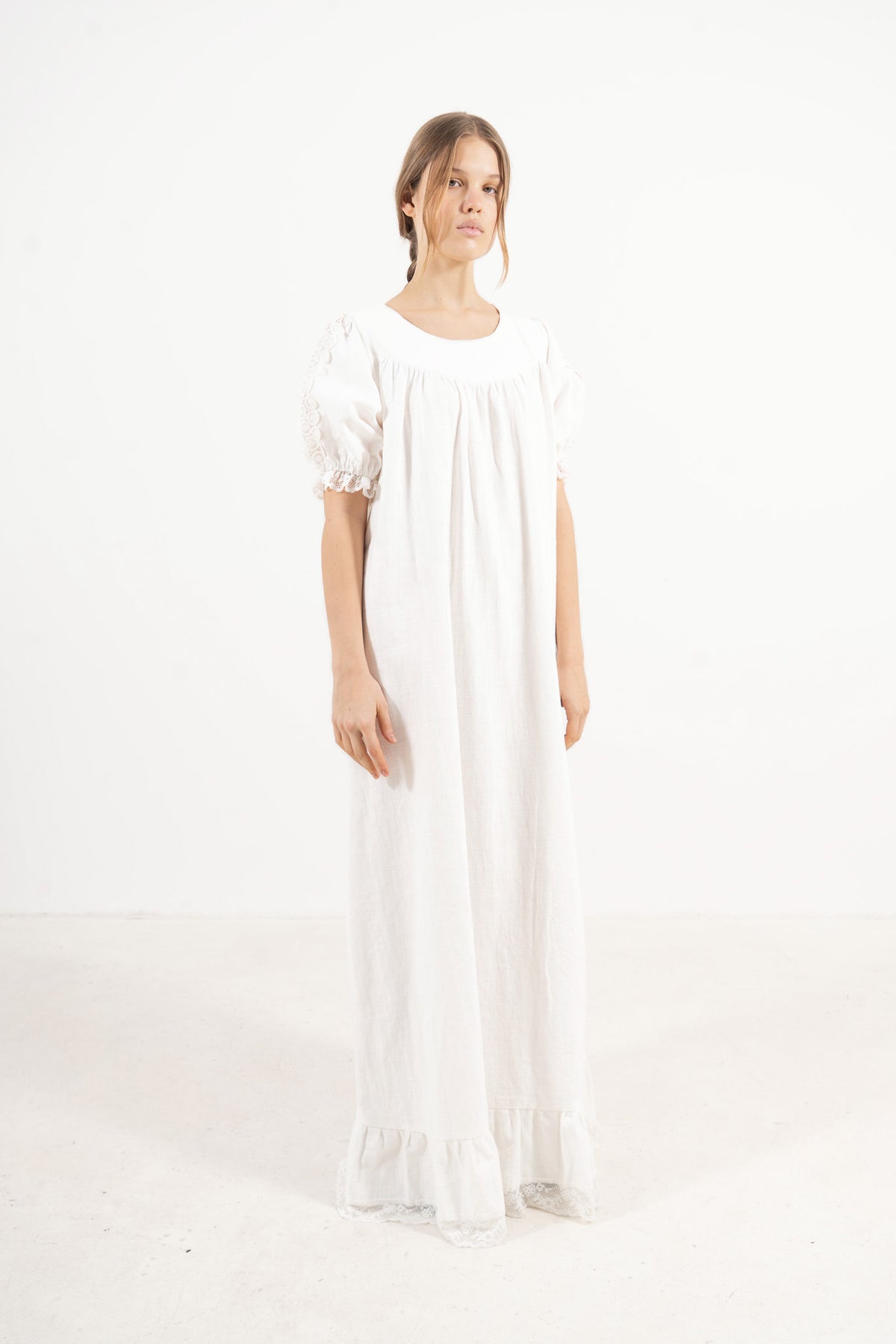 Side lookbook capture of the white organic cotton dress, emphasizing the beautiful drape, voluminous puff sleeves, and airy lightness.