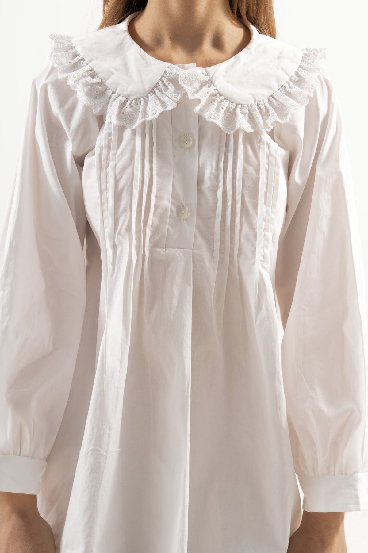 Close-up detail shot focusing on the fine stitching, delicate collar details, and premium texture of the pure MOCHA organic cotton fabric.