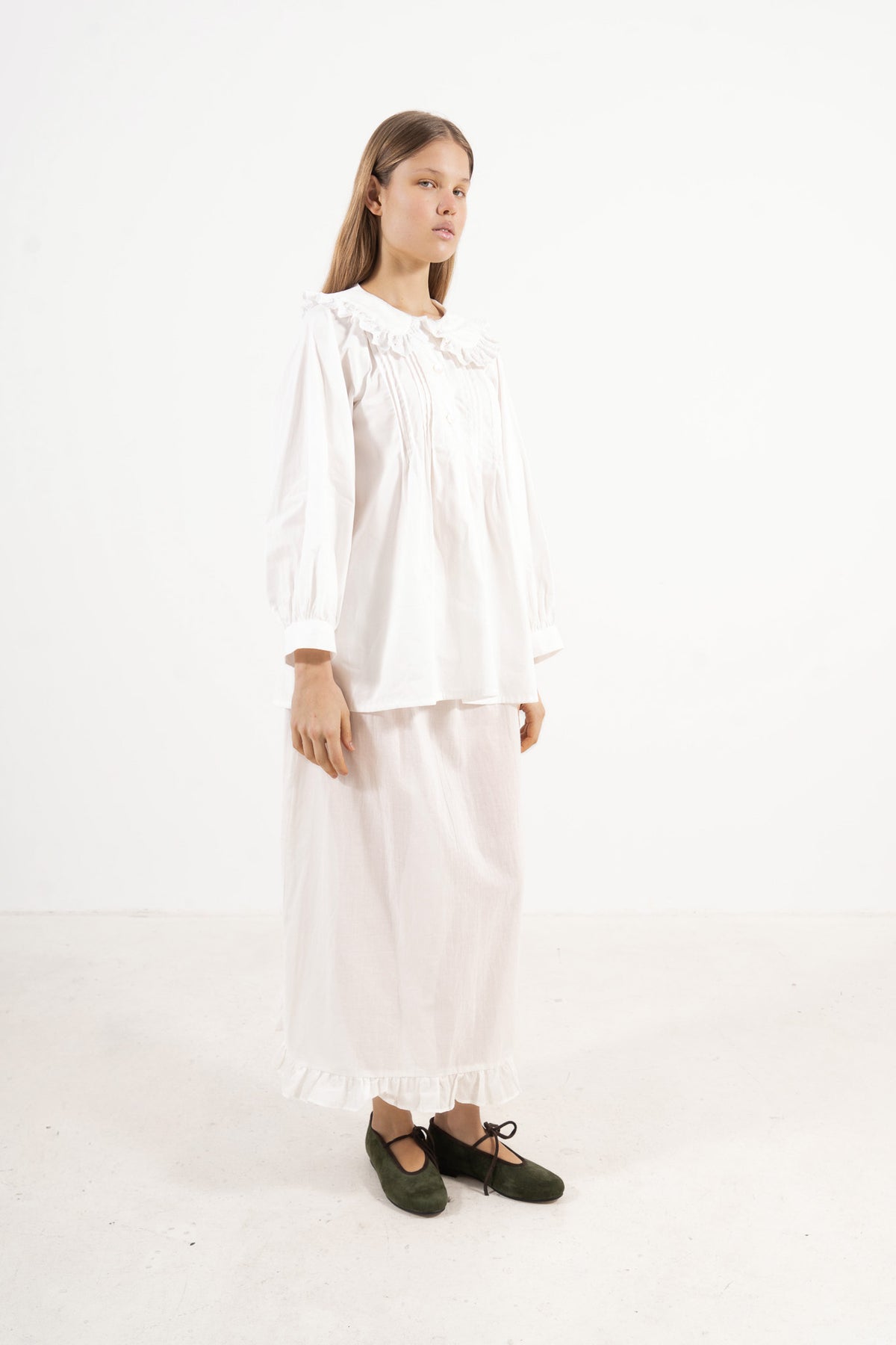 Side lookbook capture of the premium cotton blouse, emphasizing the beautiful movement of the long sleeves and flowing fabric inspired by gentle days.