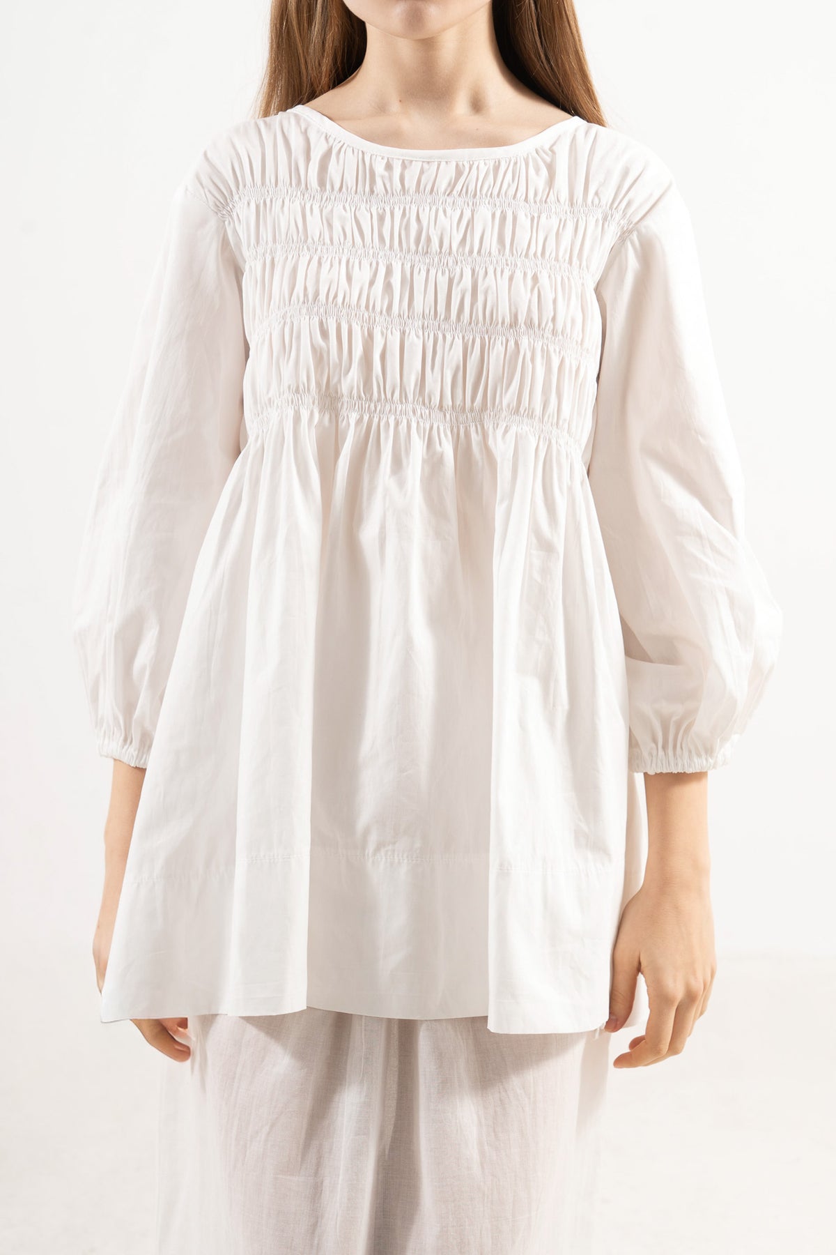Close-up detail shot focusing on the intricate stitching, delicate collar features, and majestic texture of the pure MOCHA organic cotton weave.