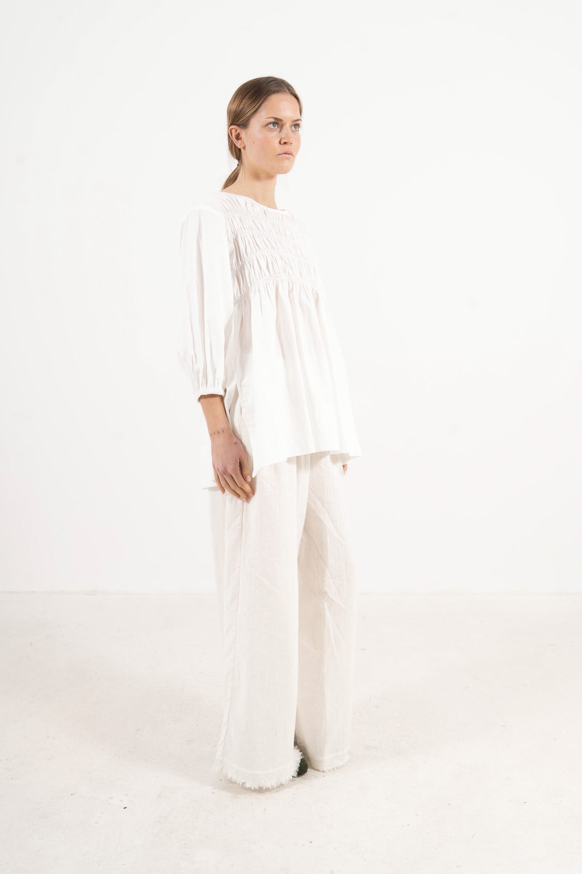 Profile studio portrait showcasing the refined structure, clean lines, and commanding presence of the MOCHA La Cour blouse.