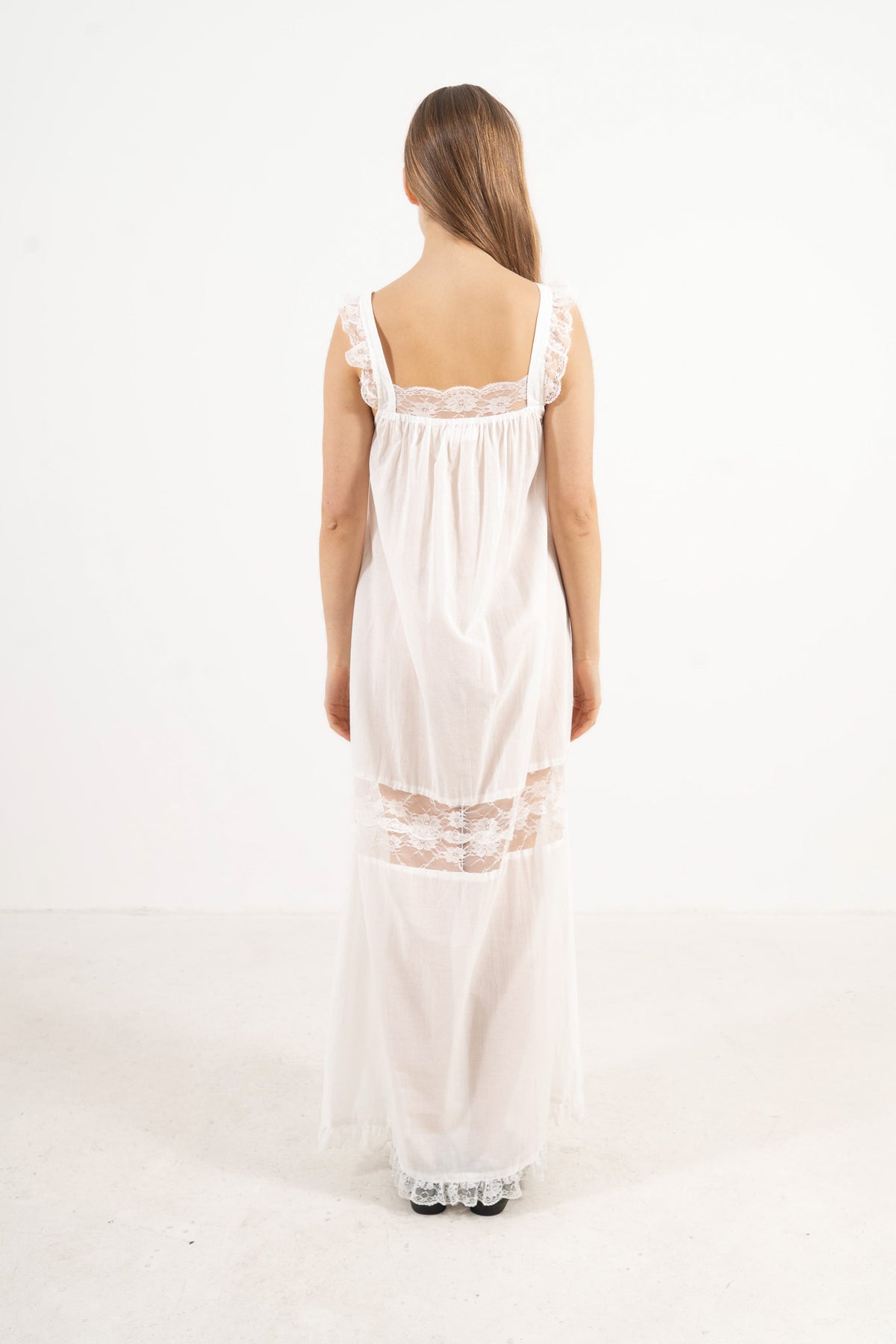 Back view of the timeless long cotton dress on a model, capturing the essence of gentle rituals and slow days at home.