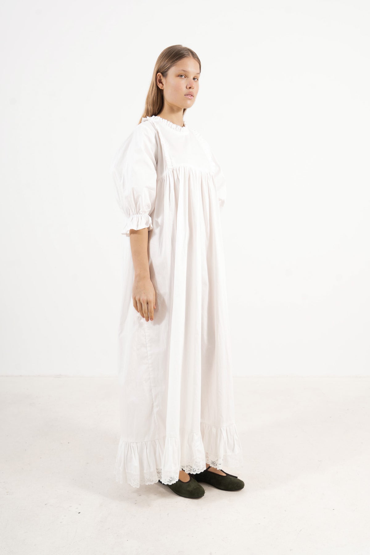Profile studio portrait showcasing the refined structure, clean lines, and commanding presence of the MOCHA Noblesse dress.
