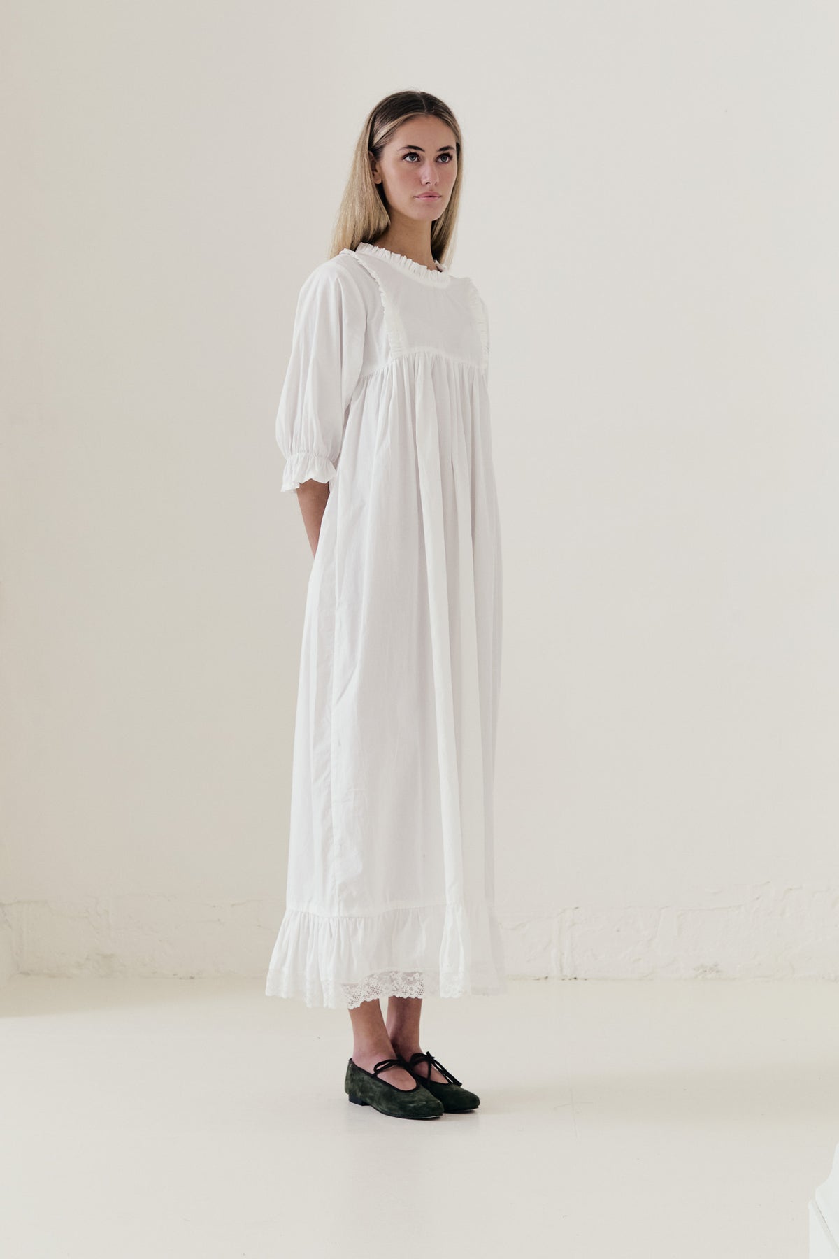 Side lookbook capture of the premium cotton dress, emphasizing the beautiful, fluid drape inspired by the timeless grandeur of the French court.