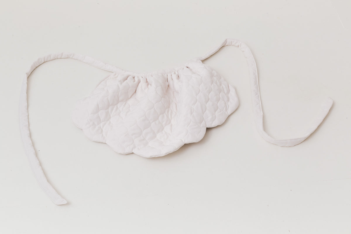 A luxurious flat layout of the MOCHA Le Petit Tablier de Poésie garment, capturing the exquisite drape of its pure cotton fabric and artistic, sophisticated tailoring layout.
