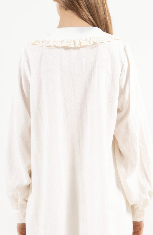 Back view of the timeless cotton blouse on a model, capturing the gentle aesthetic and quiet elegance of the piece.