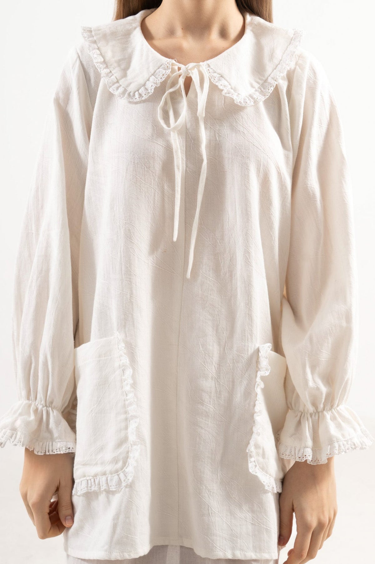Close-up detail shot focusing on the delicate collar details, fine textures, and premium craftsmanship of the MOCHA cotton fabric.