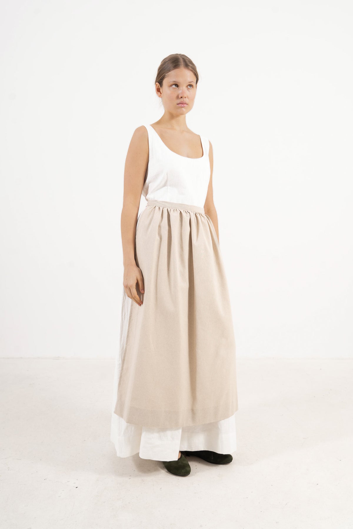 Studio lookbook portrait highlighting the elegant, relaxed fit, clean silhouette, and refined elegance of the MOCHA cotton apron.