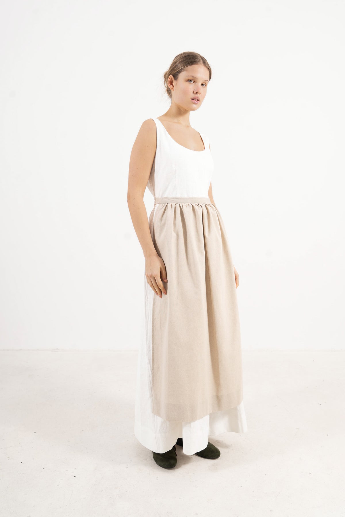 Studio lookbook portrait highlighting the elegant, relaxed fit, clean silhouette, and refined elegance of the MOCHA cotton apron.
