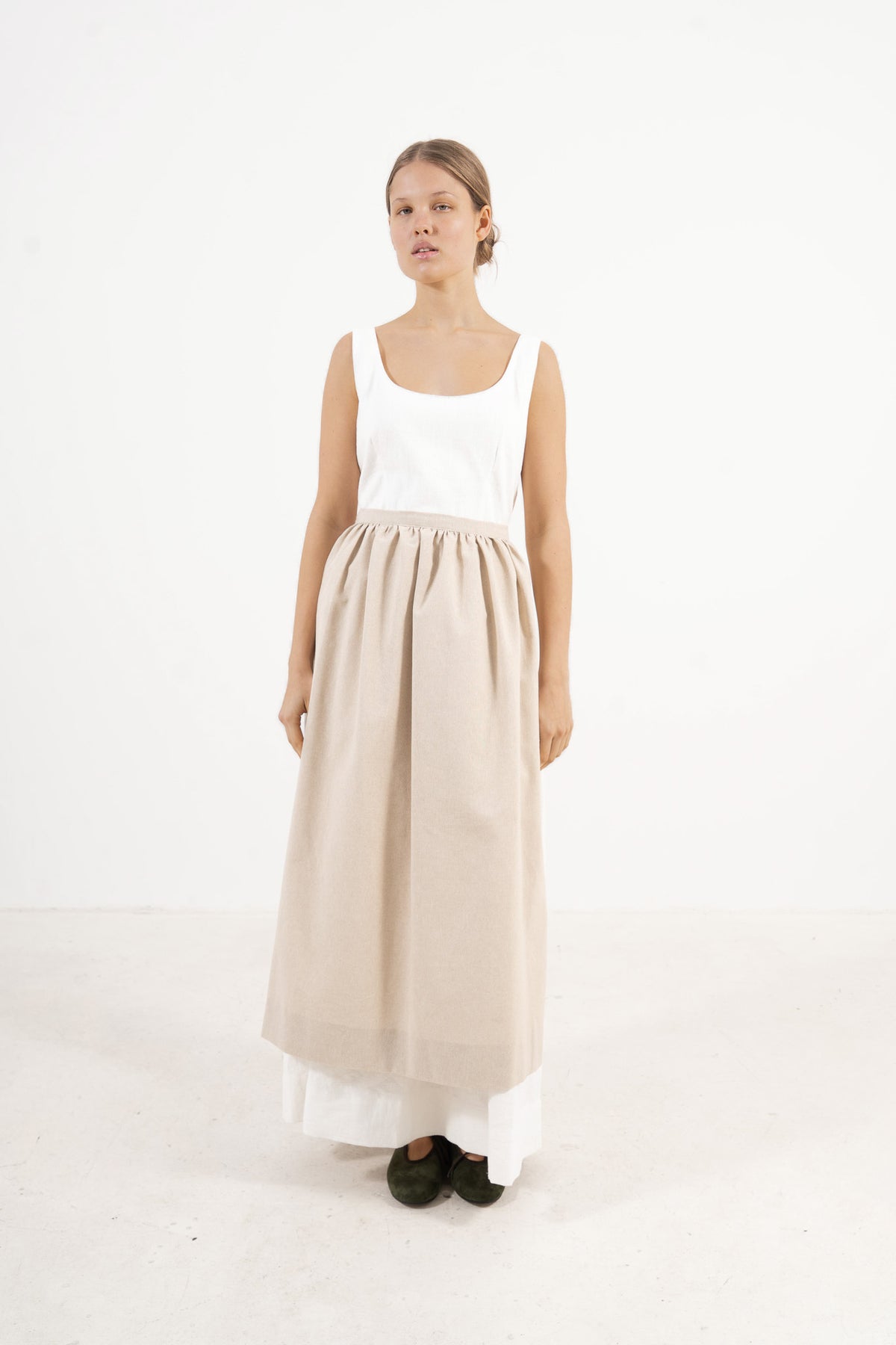 Side profile capture of the pure cotton long apron, illustrating how it serves as a beautiful accessory that adds authentic charm to every look.