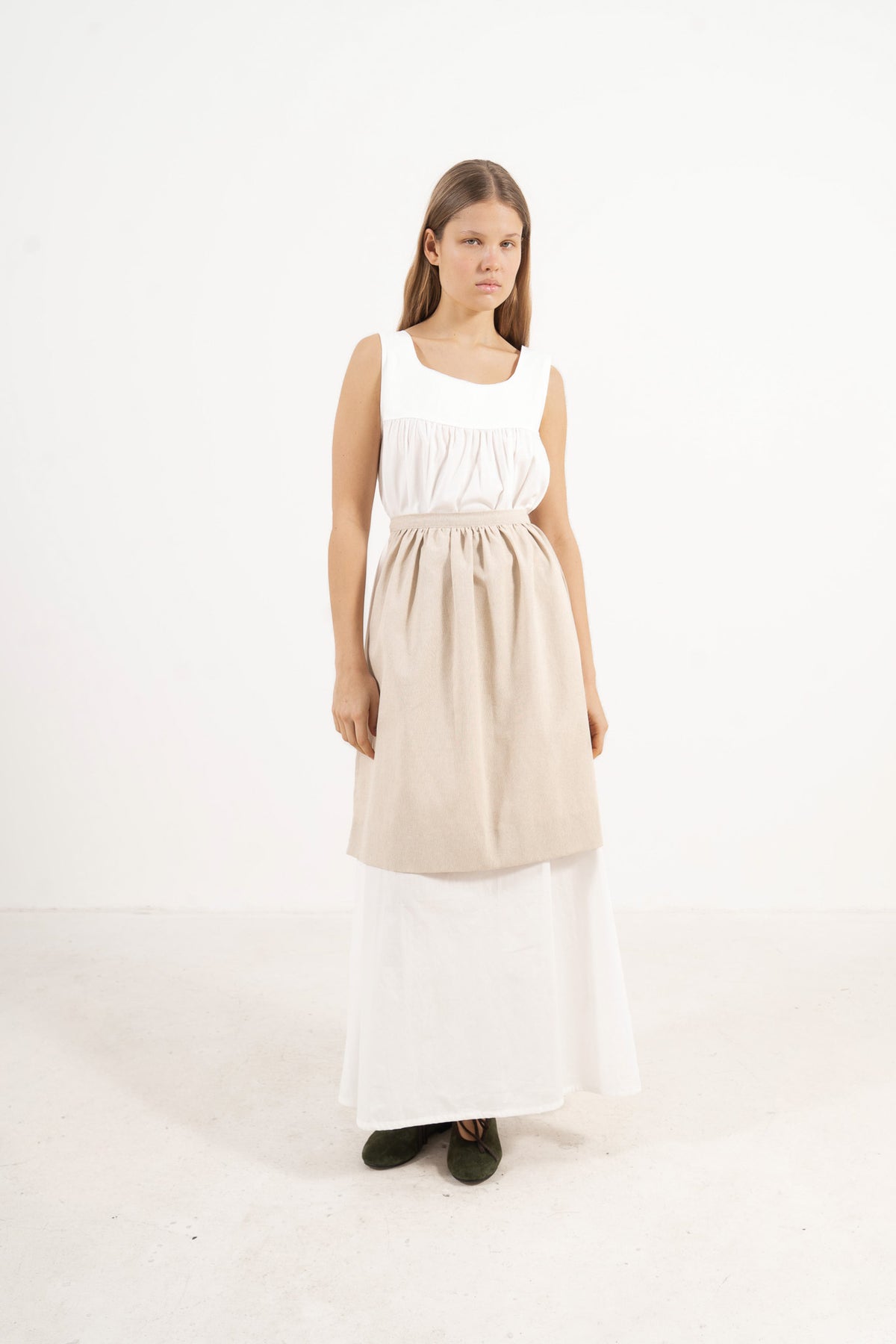 Side profile capture of the beige cotton mid apron, illustrating how it serves as an elegant accessory that brings charm and character to everyday moments.
