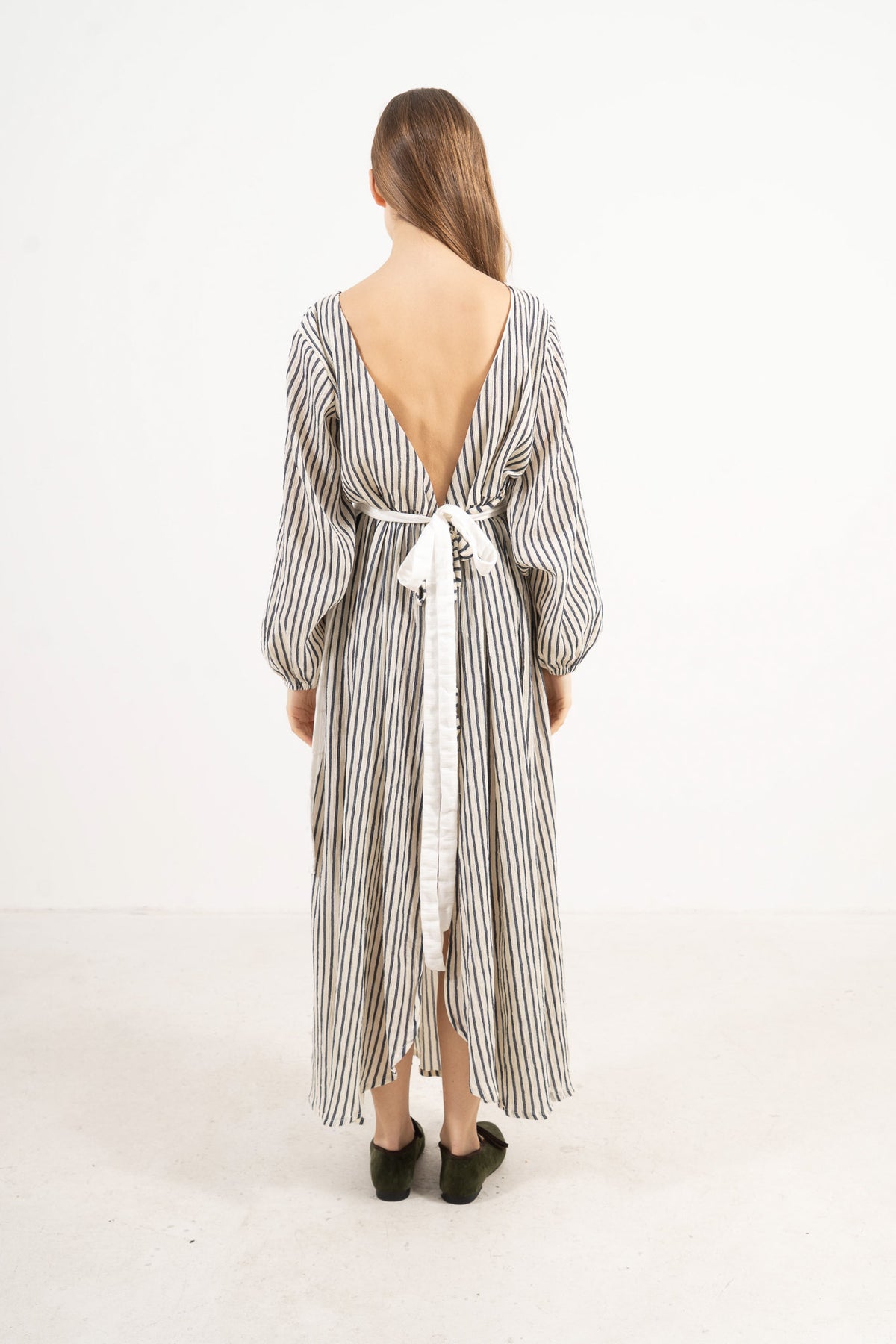 Back view of the mid apron on a model, showcasing the delicate tie straps and the fine craftsmanship of the piece.