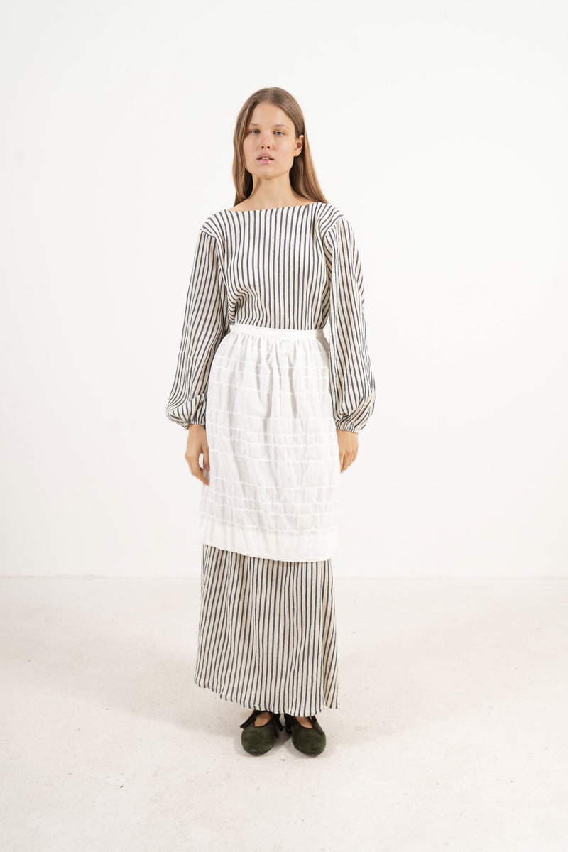 Front view lookbook image featuring a model wearing the ruffled Le Tablier mid apron by MOCHA, inspired by the quiet poetry of home.