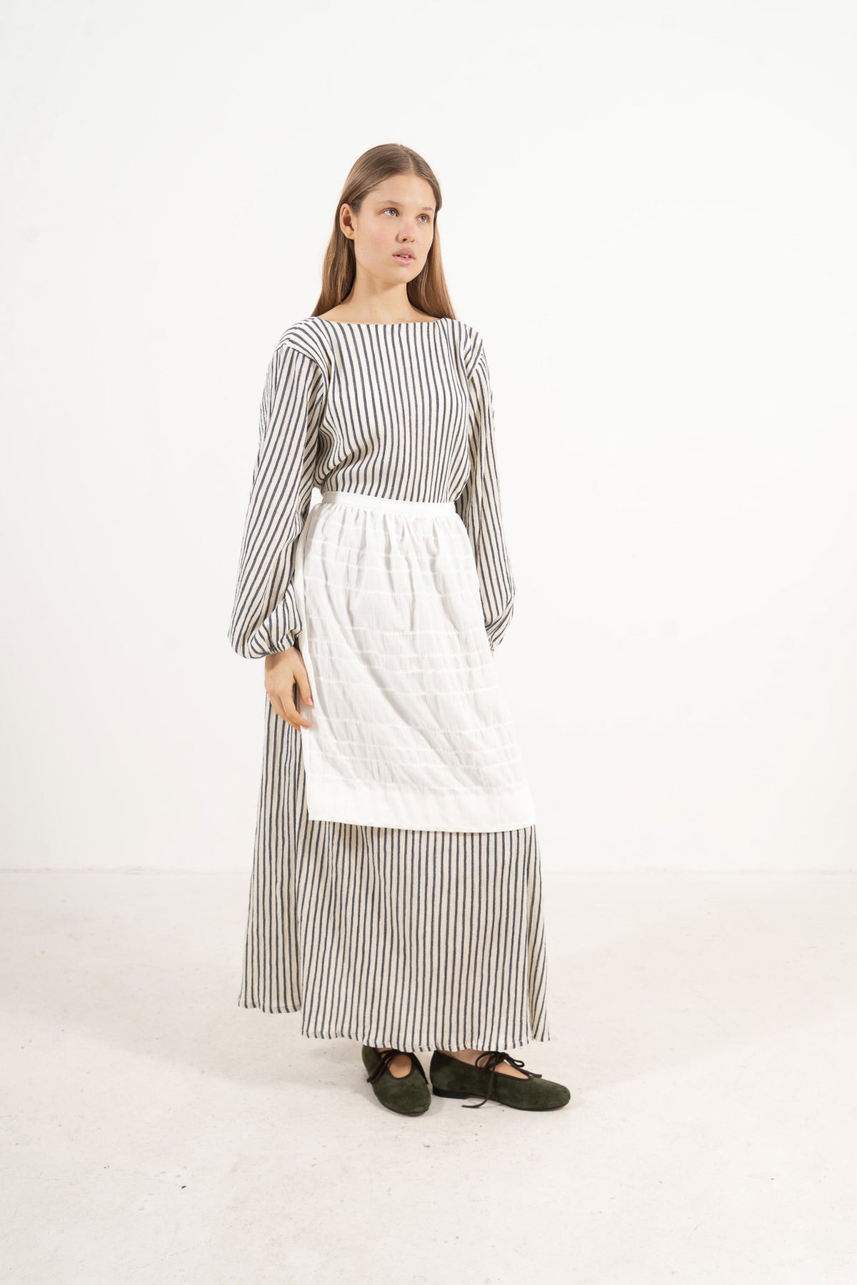 Studio lookbook portrait highlighting the relaxed fit, clean silhouette, and delicate volants of the MOCHA cotton apron.