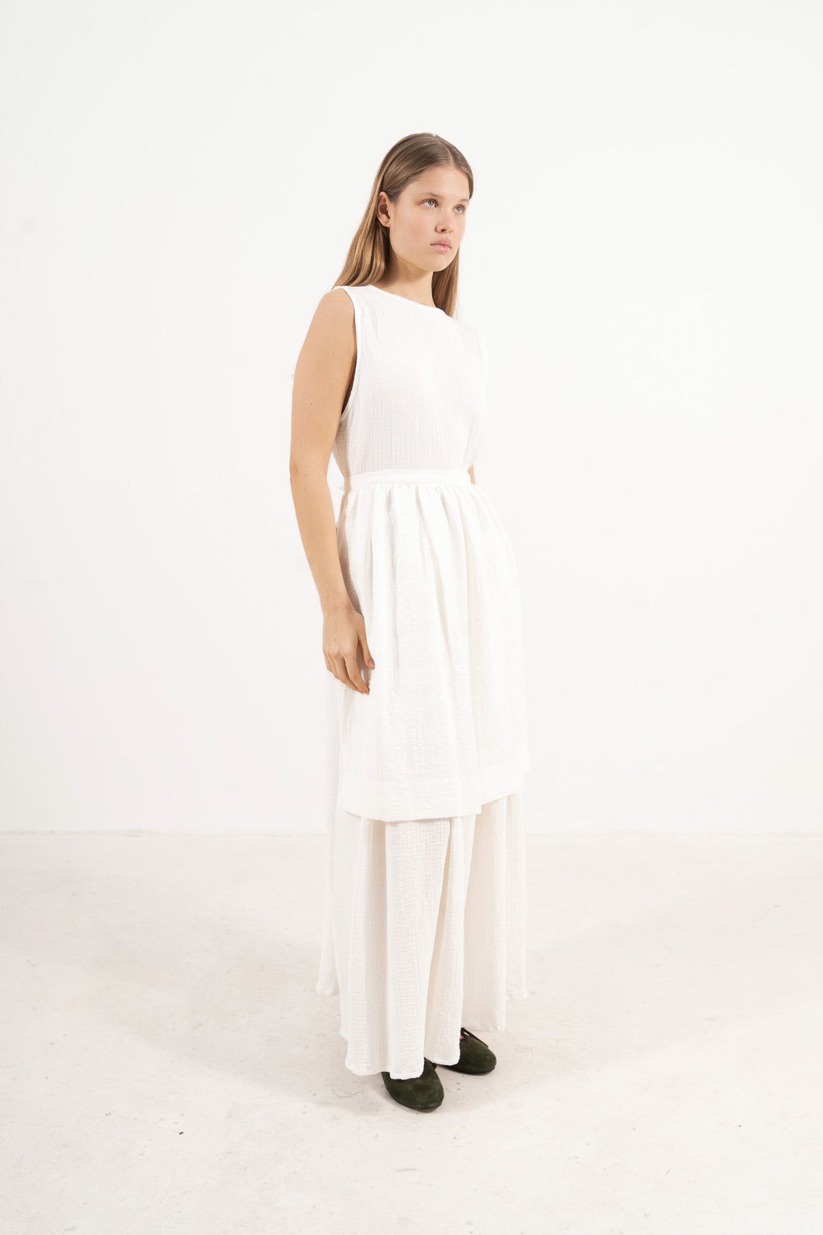 Side profile view of the MOCHA Le Tablier mid apron highlighting the fabric drape and clean silhouette design