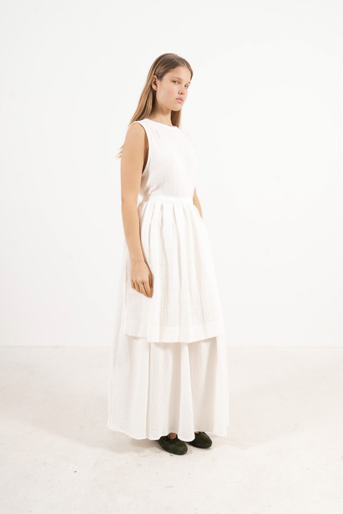 Side profile view of the MOCHA Le Tablier mid apron highlighting the fabric drape and clean silhouette design.