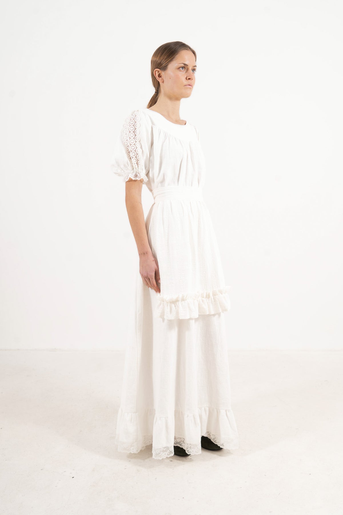 Studio lookbook portrait highlighting the elegant, relaxed silhouette and clean styling of the MOCHA cotton apron.