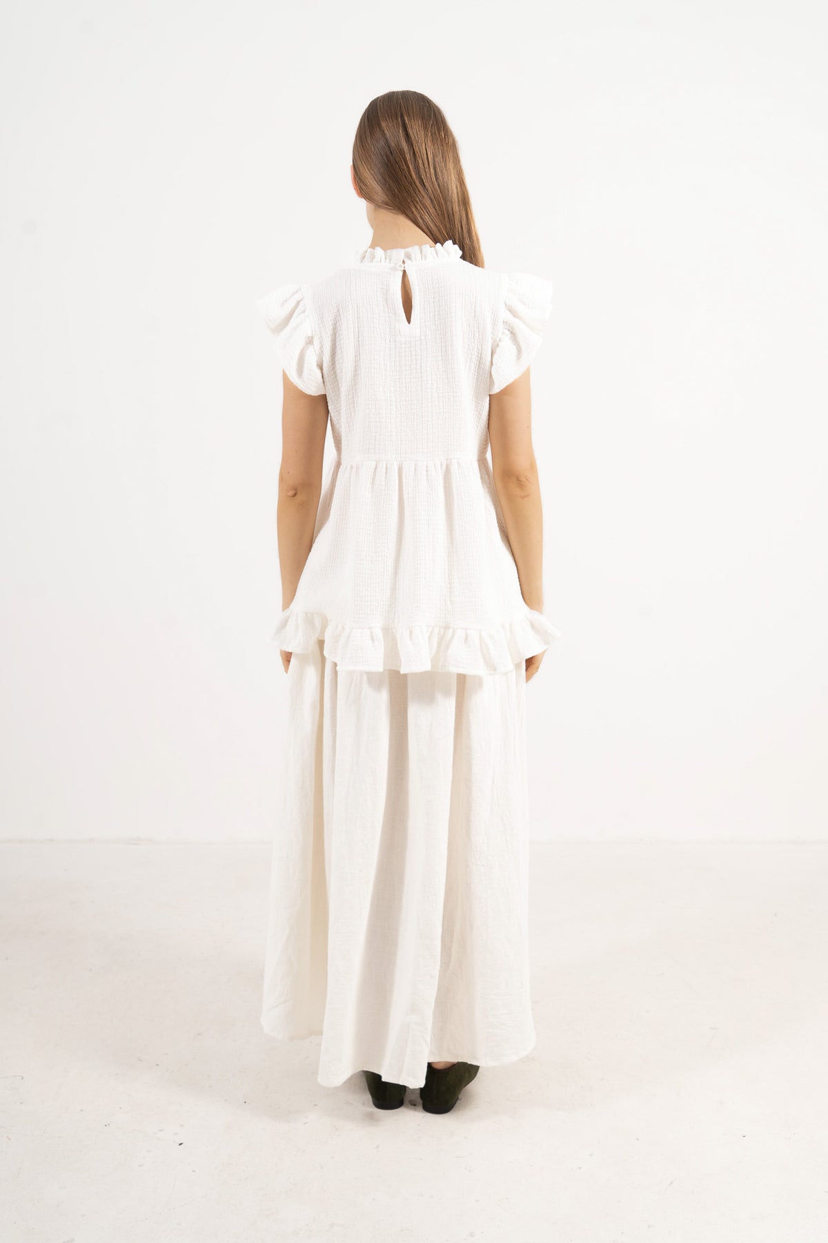 Back view of the classic cotton top on a model, capturing a soft world of lightness, ease, and premium tailoring.