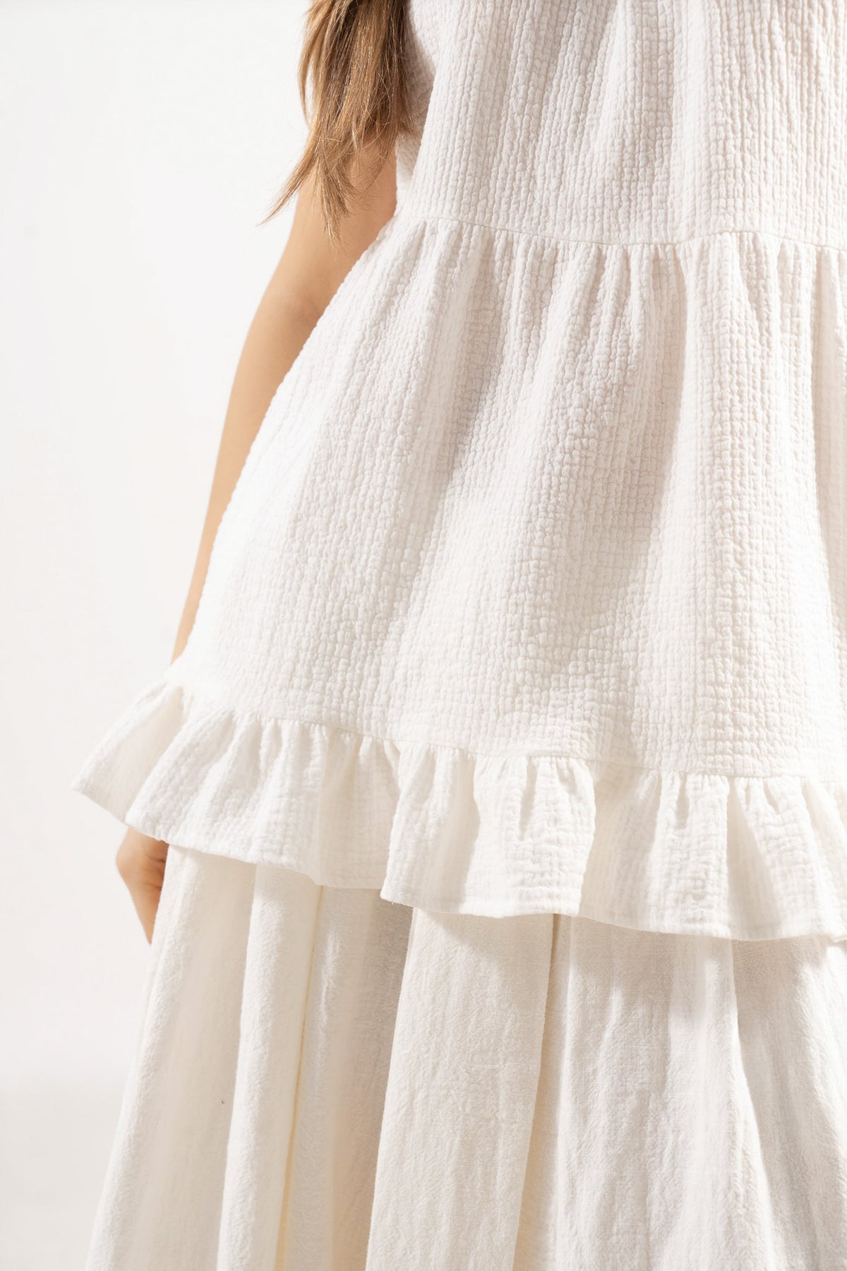 Close-up detail shot focusing on the beautifully ruffled accents and the exquisite texture of the pure MOCHA soft cotton weave.