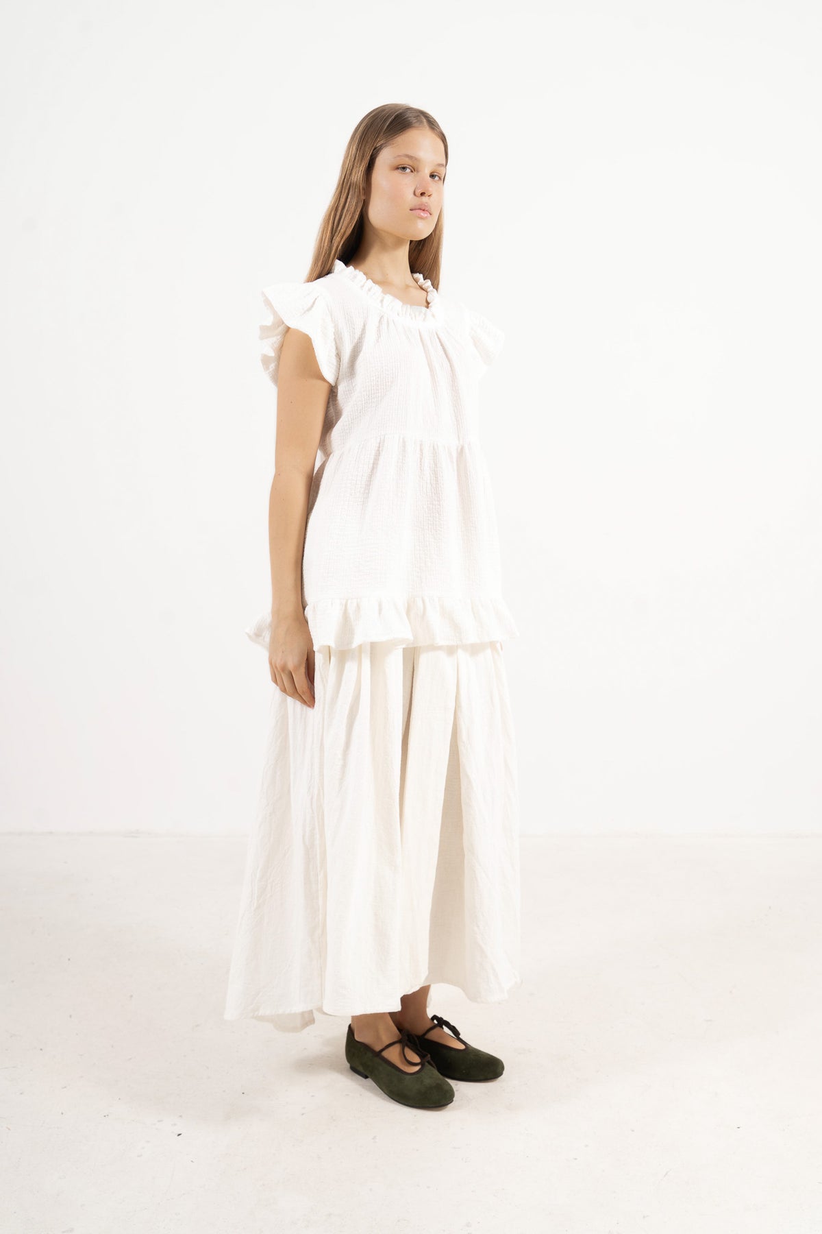 Profile studio portrait showcasing the versatile fit, clean lines, and relaxed, graceful structure of the MOCHA Céline top.