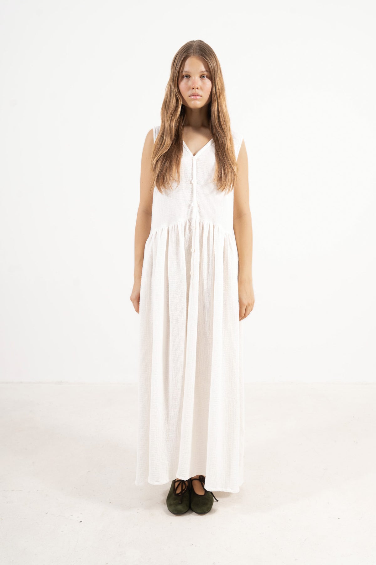 An elegant front view of the MOCHA Nuage long dress, meticulously crafted from the finest pure soft cotton, draped beautifully upon a pristine white floor.