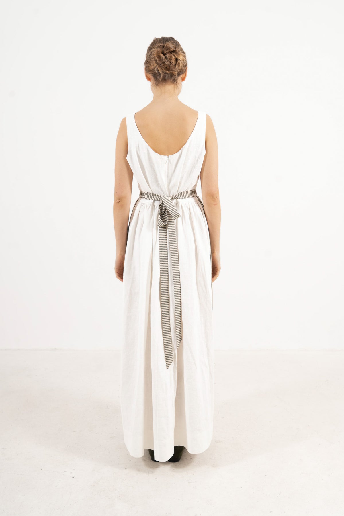 Back view of the striped Le Tablier Apron by MOCHA, showcasing the elegant rear drape, crossed tie straps, and refined closure details.