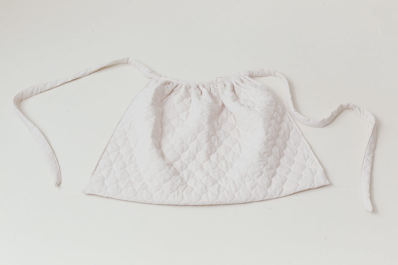 Detailed close-up focusing on the premium pure cotton weave and authentic tactile texture of the MOCHA Le Tablier de Poésie.